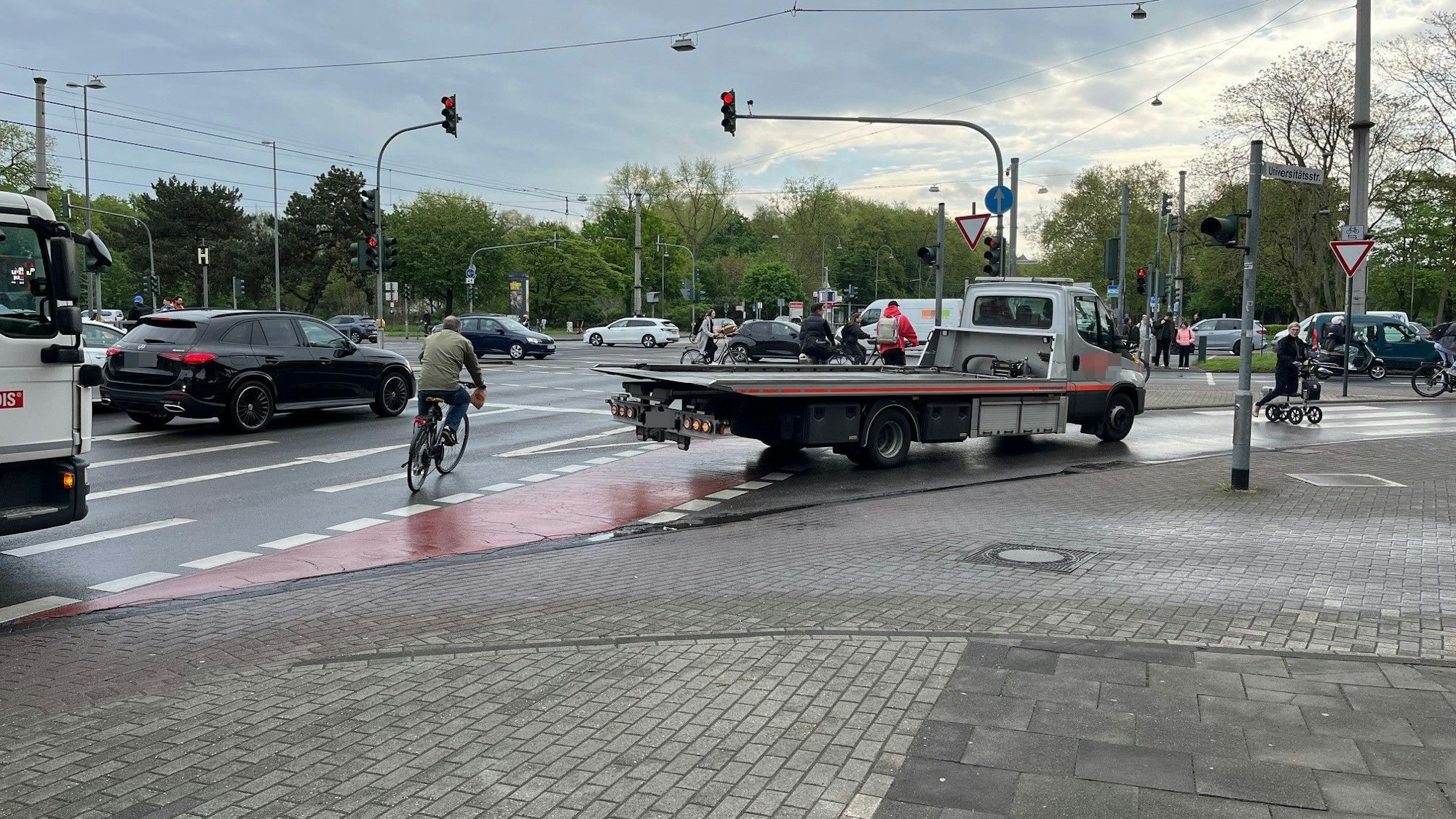 Der Abschleppwagen ragt auf den Radweg, der Radler weicht ihm aus. Die Kreuzung Aachener Straße/Universitätsstraße/Innere Kanalstraße ist ein Unfallschwerpunkt.