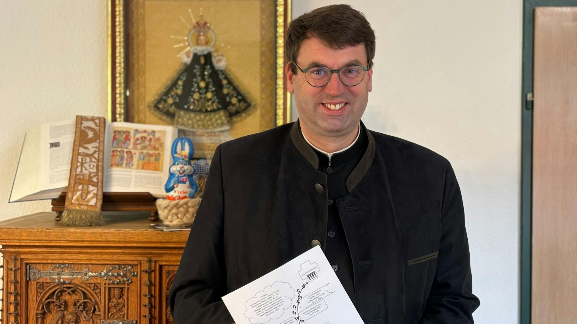 Pfarrer Guido Zimmermann hält einen Zettel mit einem Plan zu den Fusionen der Kirchengemeinden Weilerswist und Zülpich