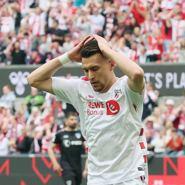 Ein Fußballspieler schlägt seine Hände über dem Kopf zusammen.