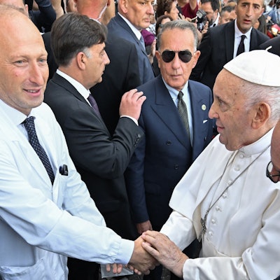 Sergio Alfieri (l.) schüttelt Papst Franziskus die Hand nach einem Krankenhausaufenthalt des Pontifex im Jahr 2023.