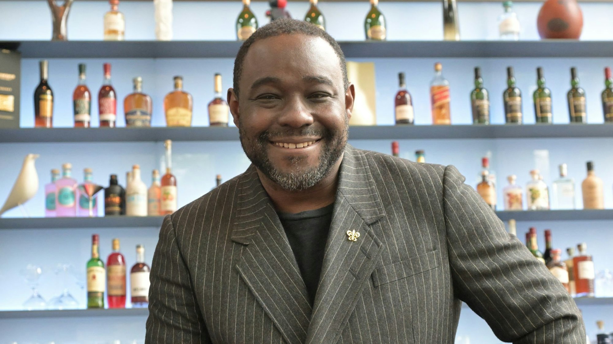 Nelson Müller sitzt in der Diepischrather Mühle. Im Hintergrund befinden sich unscharf gestellte Spirituosen.