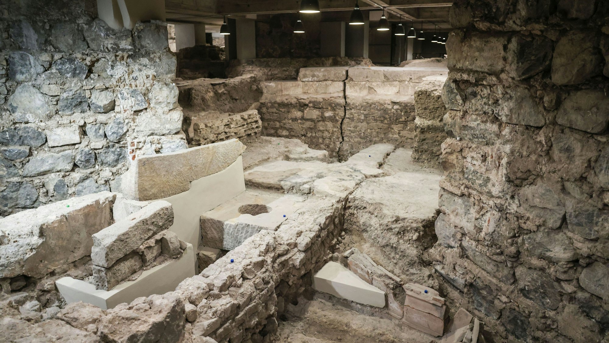 PRODUKTION - 31.03.2025, Nordrhein-Westfalen, Köln: Ein römischer Gully (M) ist in derAusgrabung unter dem Fundament des Domes zu sehen. (zu dpa: «Gräber, Gold und Gullys - Expedition unter den Kölner Dom») Foto: Oliver Berg/dpa +++ dpa-Bildfunk +++