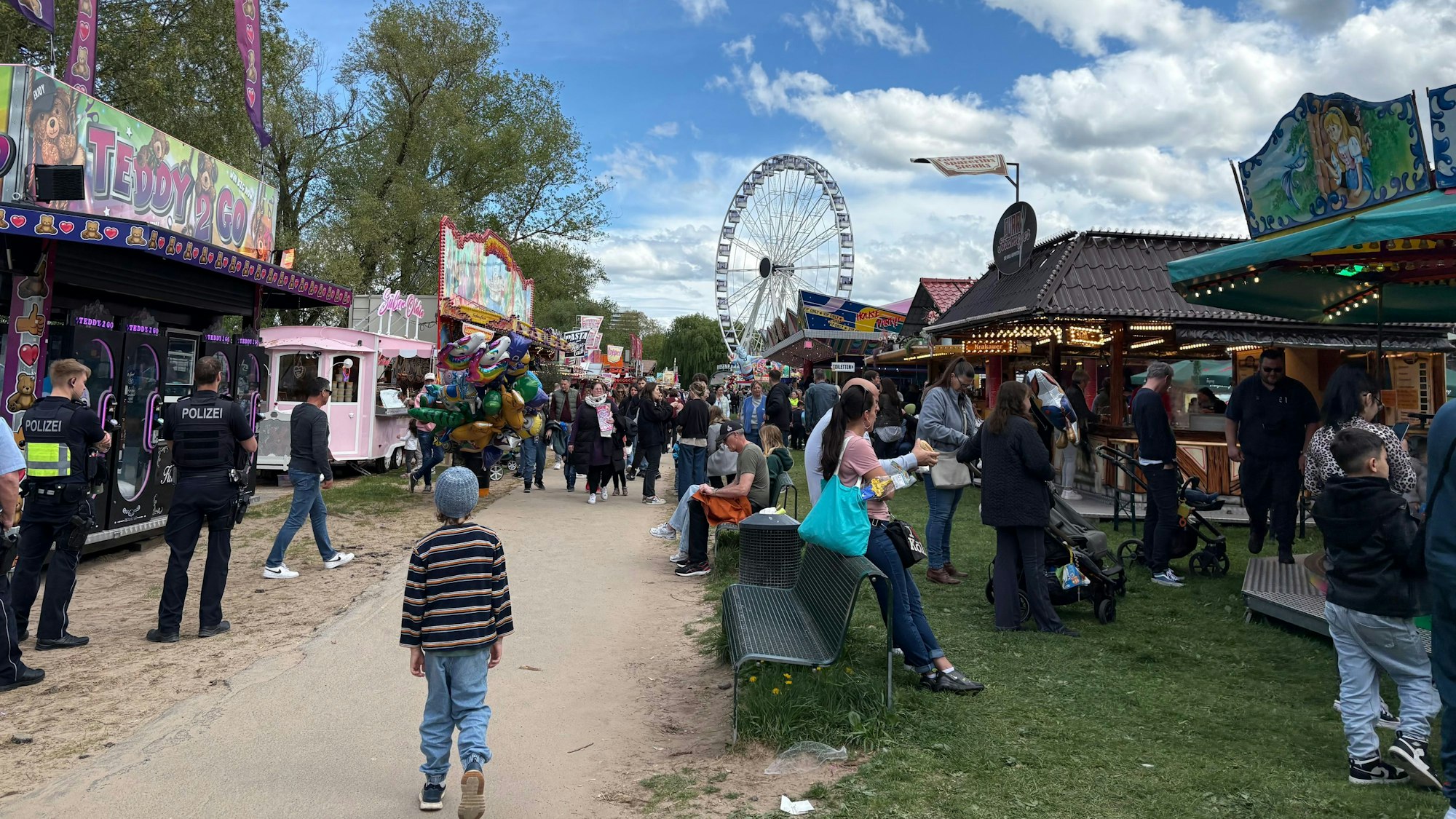 Besuchende auf der Kirmes an Ostern 2025 in Rodenkirchen – hier noch mit Riesenrad.