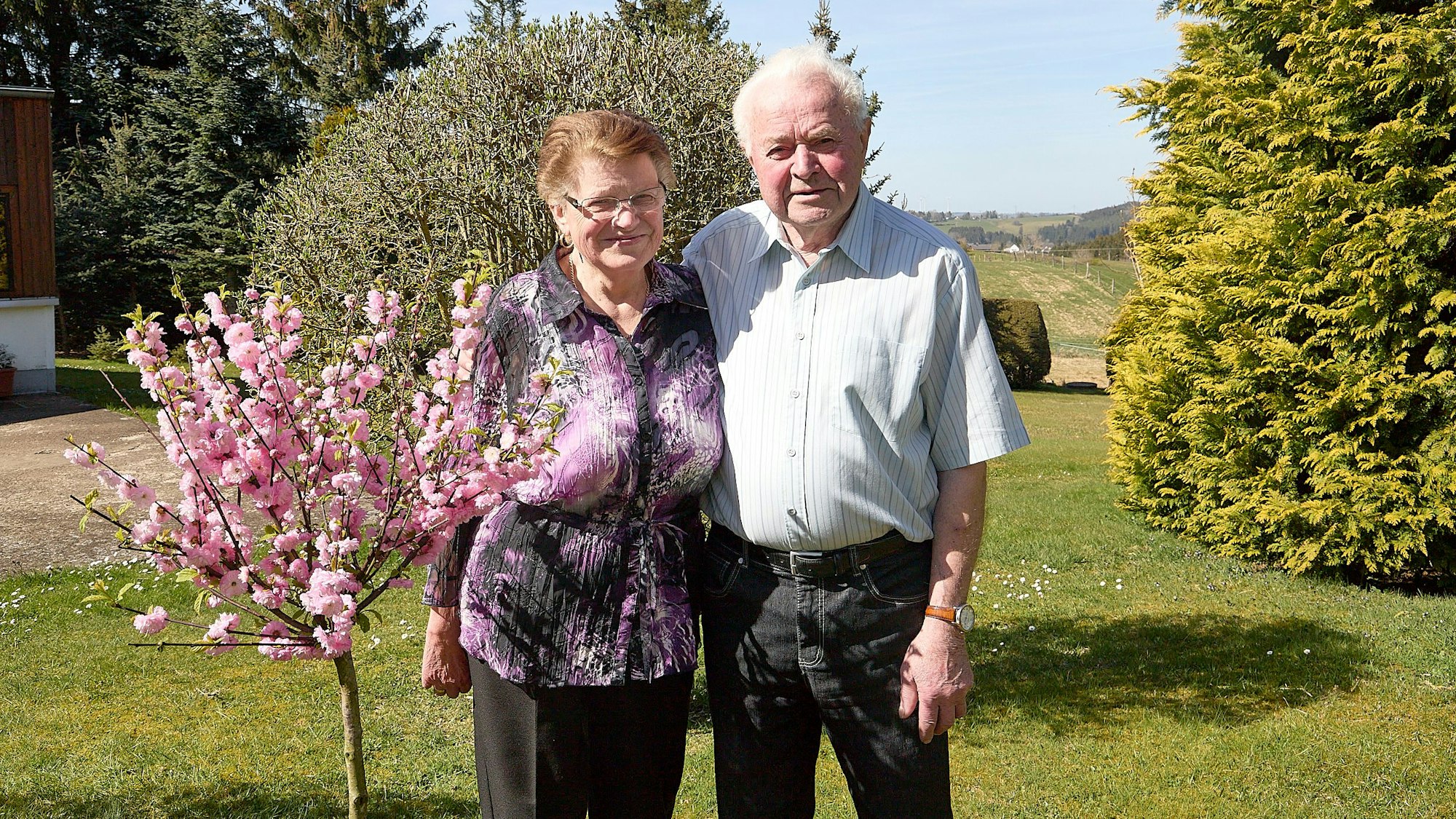 Ingeborg und Wilhelm Hermes stehen neben einem blühenden Bäumchen.