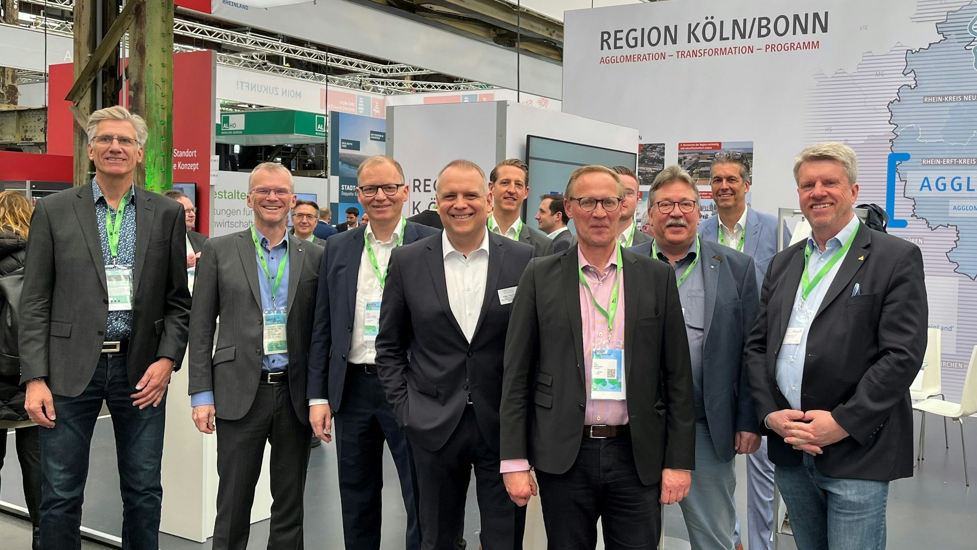 Menschen stehen vor einem Messestand.