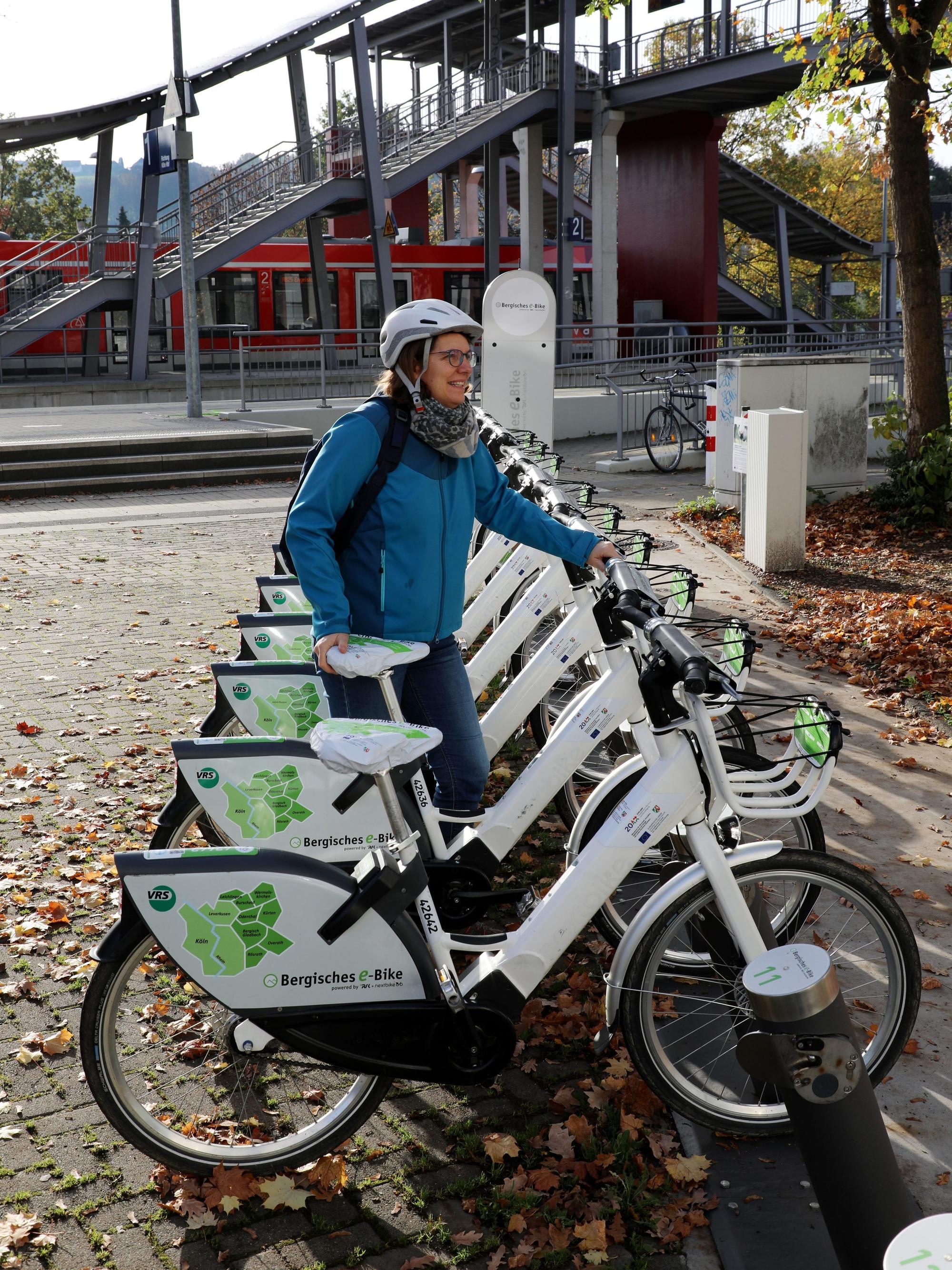 Eine Frau leiht ein Bergisches E-Bike an der Mobilstation am Overather Bahnhof aus.