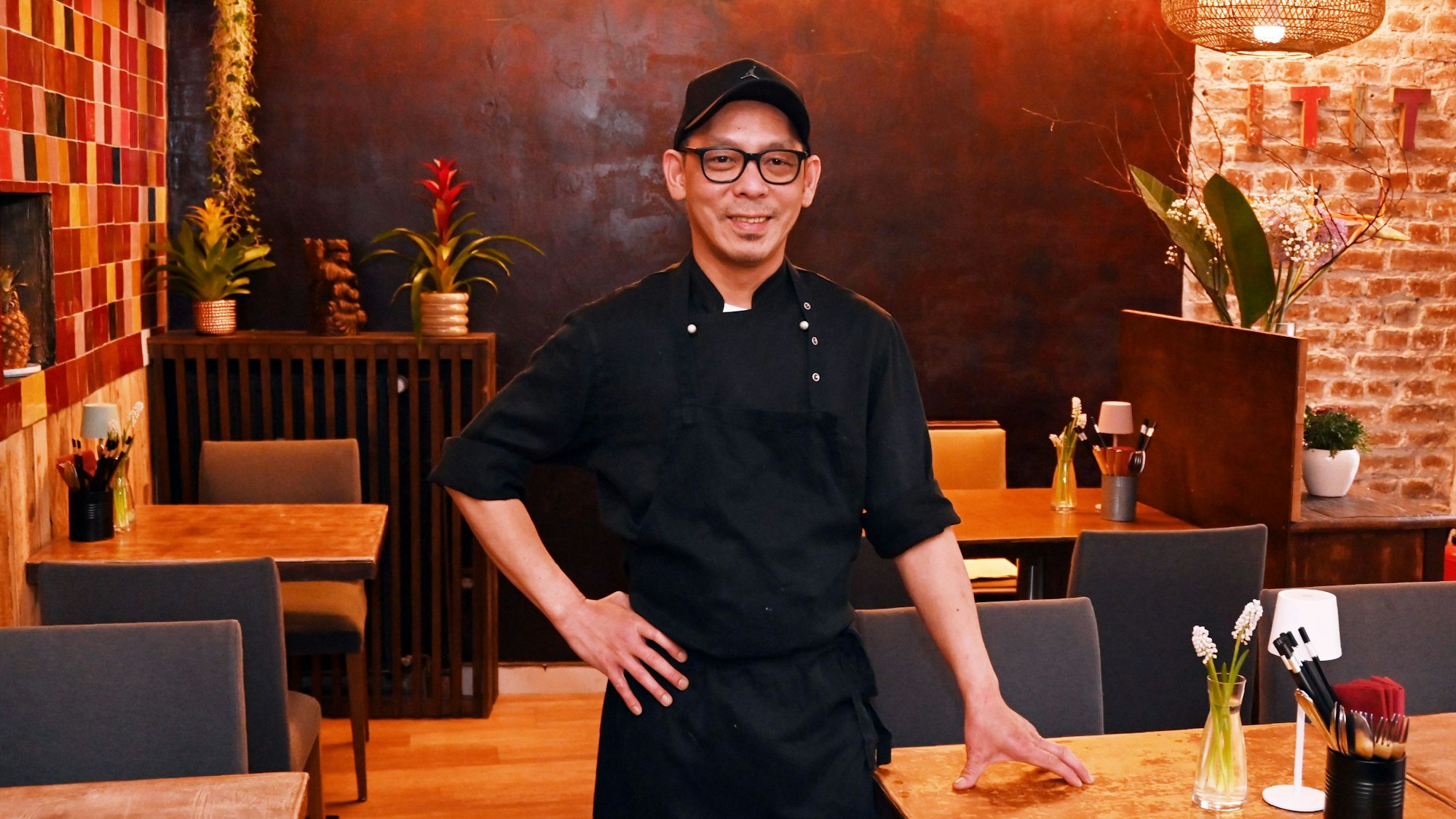 Chef Hoa Hiep Lam ist im Gastraum zu sehen - er lächelt in die Kamera.