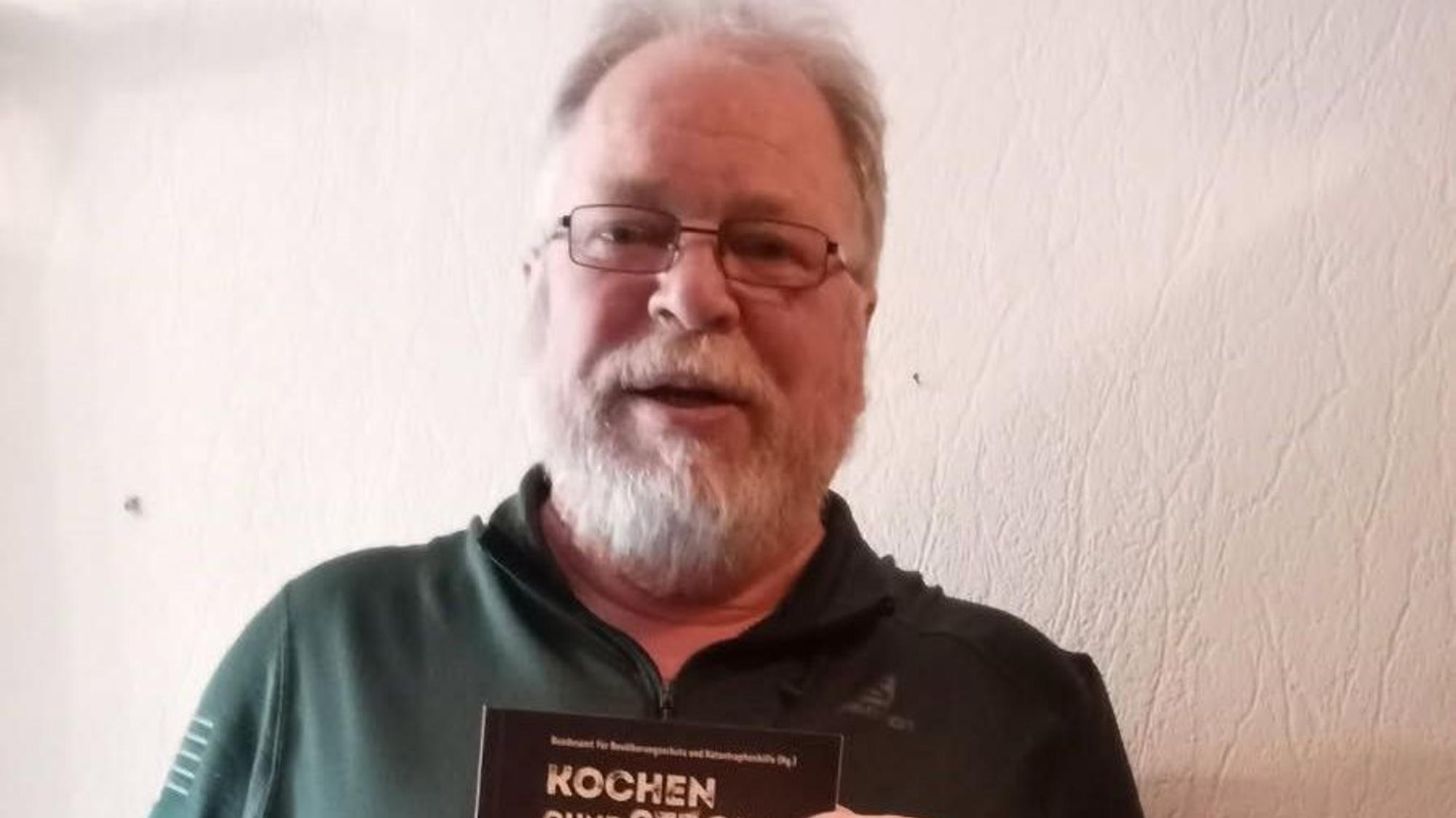 Zu sehen ist ein Mann mit grauen Haaren und Brille.