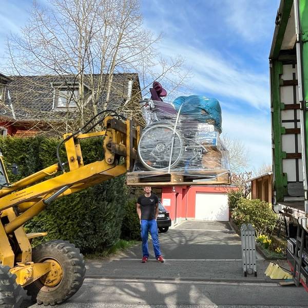 Ein Bagger verlädt Hilfsgüter in einen LKW.