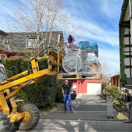 Ein Bagger verlädt Hilfsgüter in einen LKW.