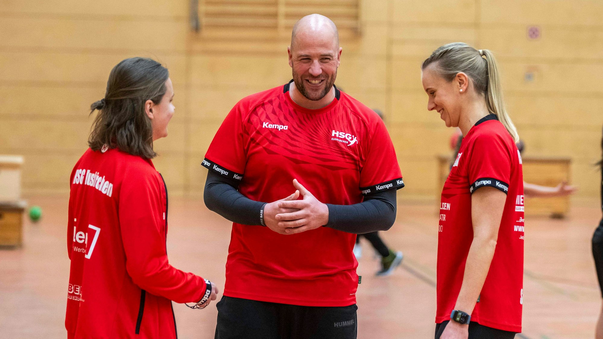 Eine Jugendtrainerin ist im Gespräch mit den beiden Jugendkoordinatoren.