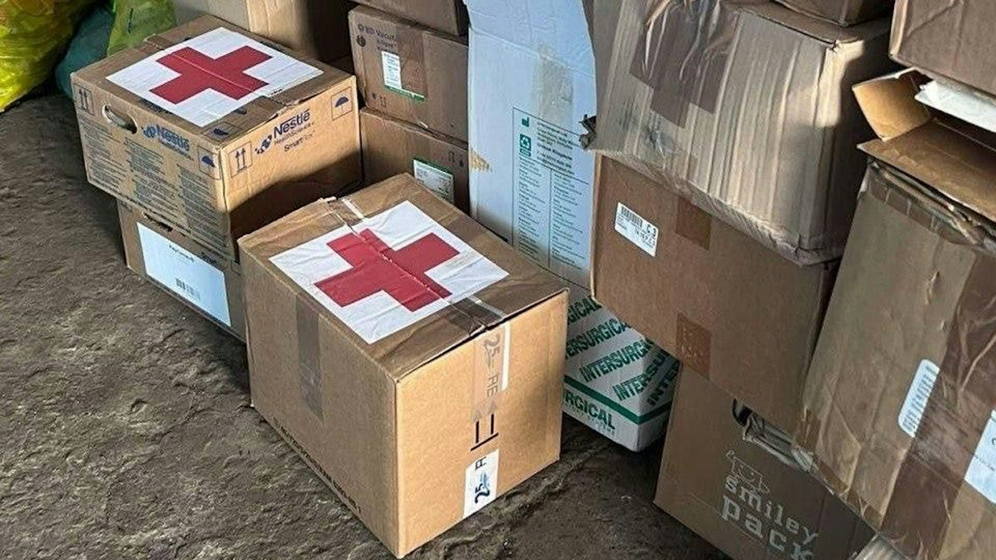 Kartons mit dicken roten Kreuzen auf weißem Grund stehen nebeneinander.