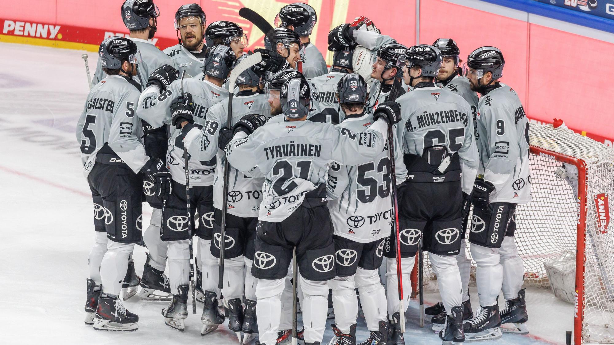 Spieler der Kölner Haie stehen nach der Niederlage zusammen auf dem Eis.