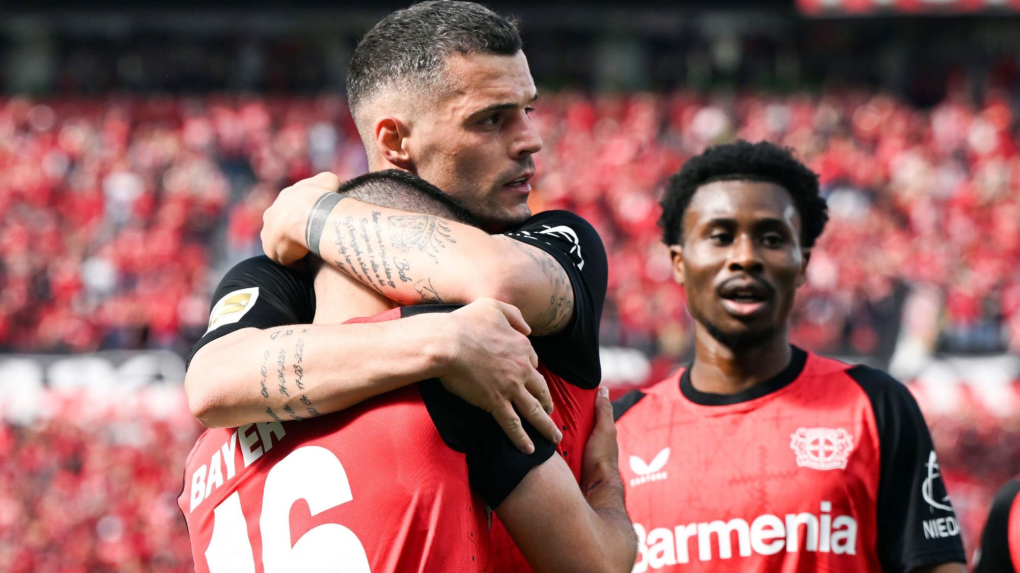 Leverkusens Emiliano Buendia (vorn) bejubelt sein Tor zum 2:0 mit Granit Xhaka und Nathan Tella (r.).