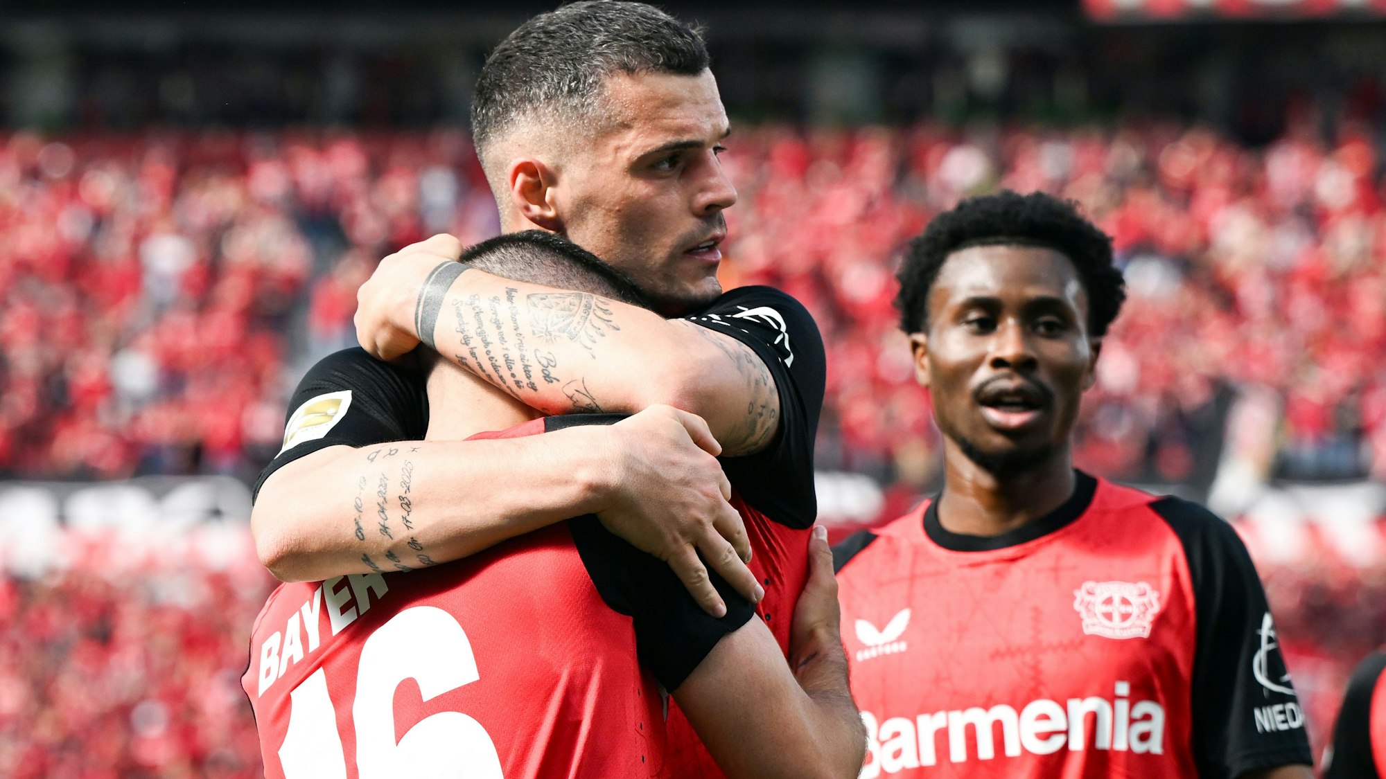 Leverkusens Emiliano Buendia (vorn) bejubelt sein Tor zum 2:0 mit Granit Xhaka und Nathan Tella (r.).