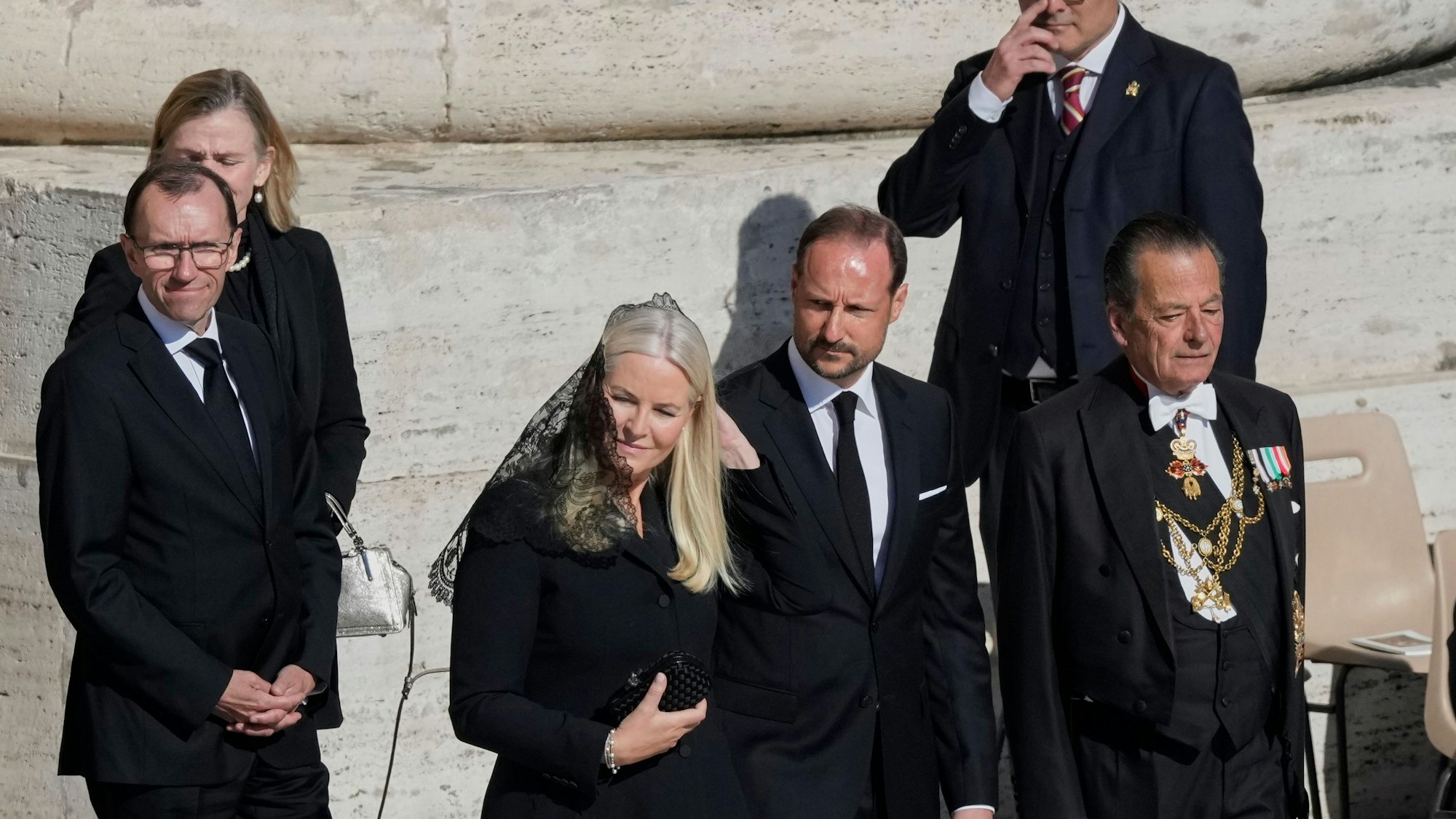 Kronprinz Haakon von Norwegen (m,r) und Mette-Marit, Kronprinzessin von Norwegen, kommen zur Trauermesse für den verstorbenen Papst Franziskus auf dem Petersplatz.