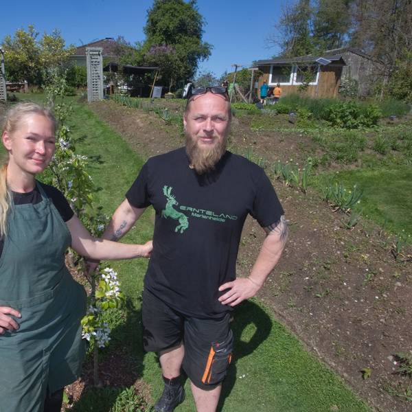 Ein Ehepaar steht in ihrem Garten – einem ökologischen Anbauprojekt.