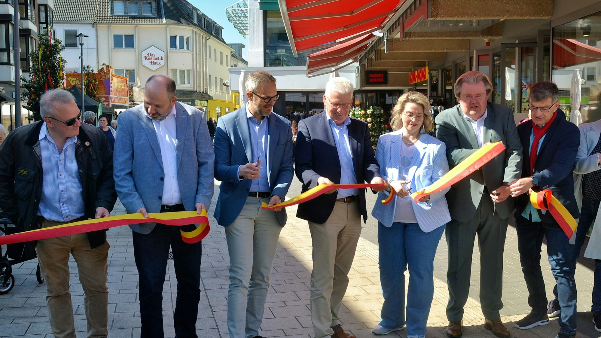 Mehrere Personen stehen hinter dem Band, das soeben durchschnitten wurde.