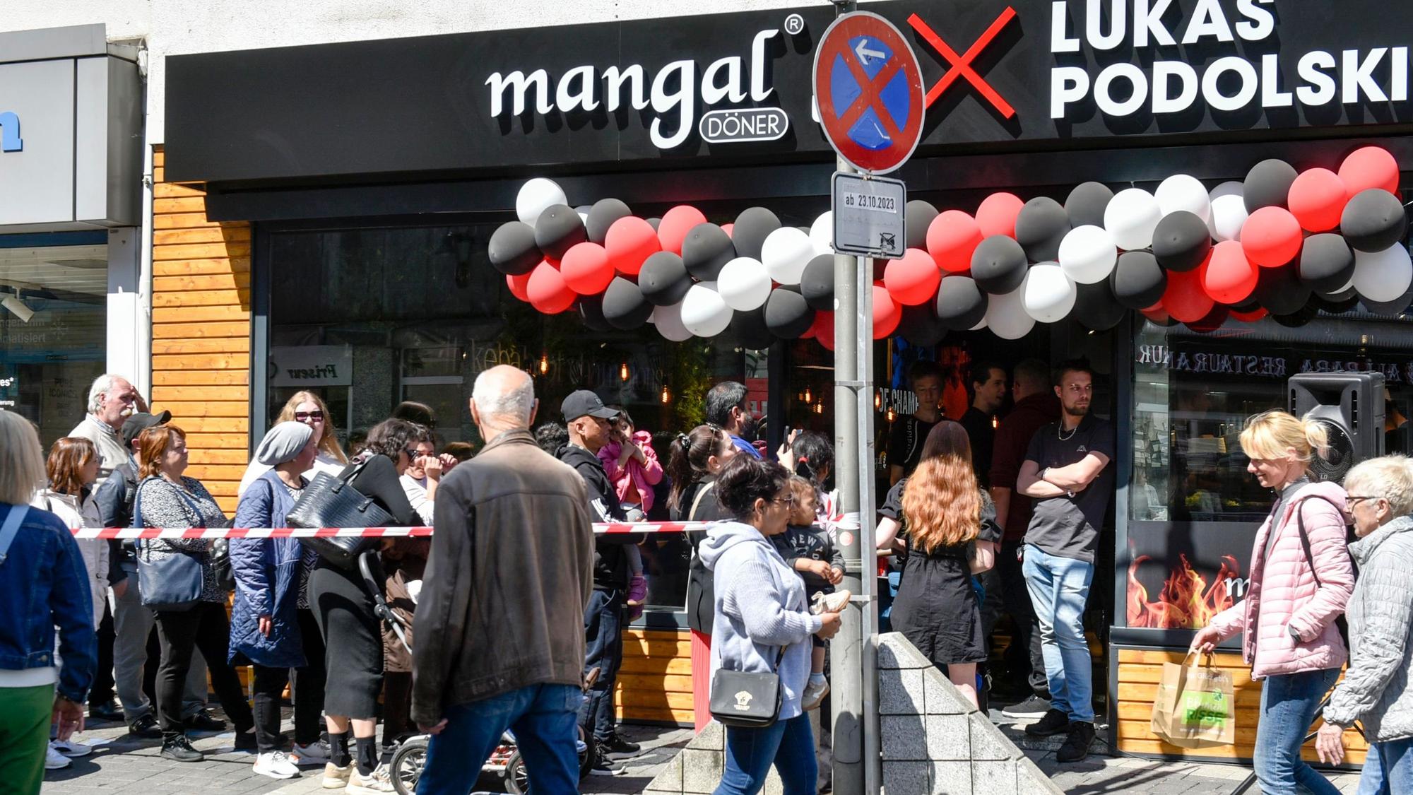 Das Bild zeigt eine Menschenschlange vor der Filiale Mangel Döner.