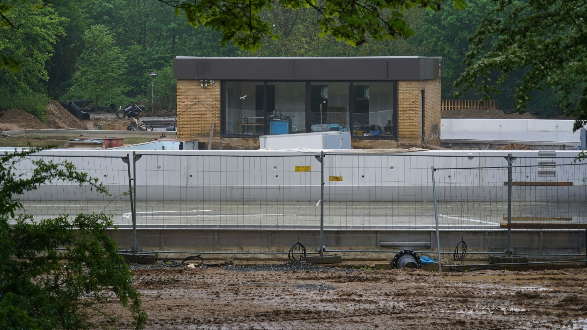 Auf dem Bild ist die Baustelle und ein Bauzaun im Freibad Frechen zu sehen.