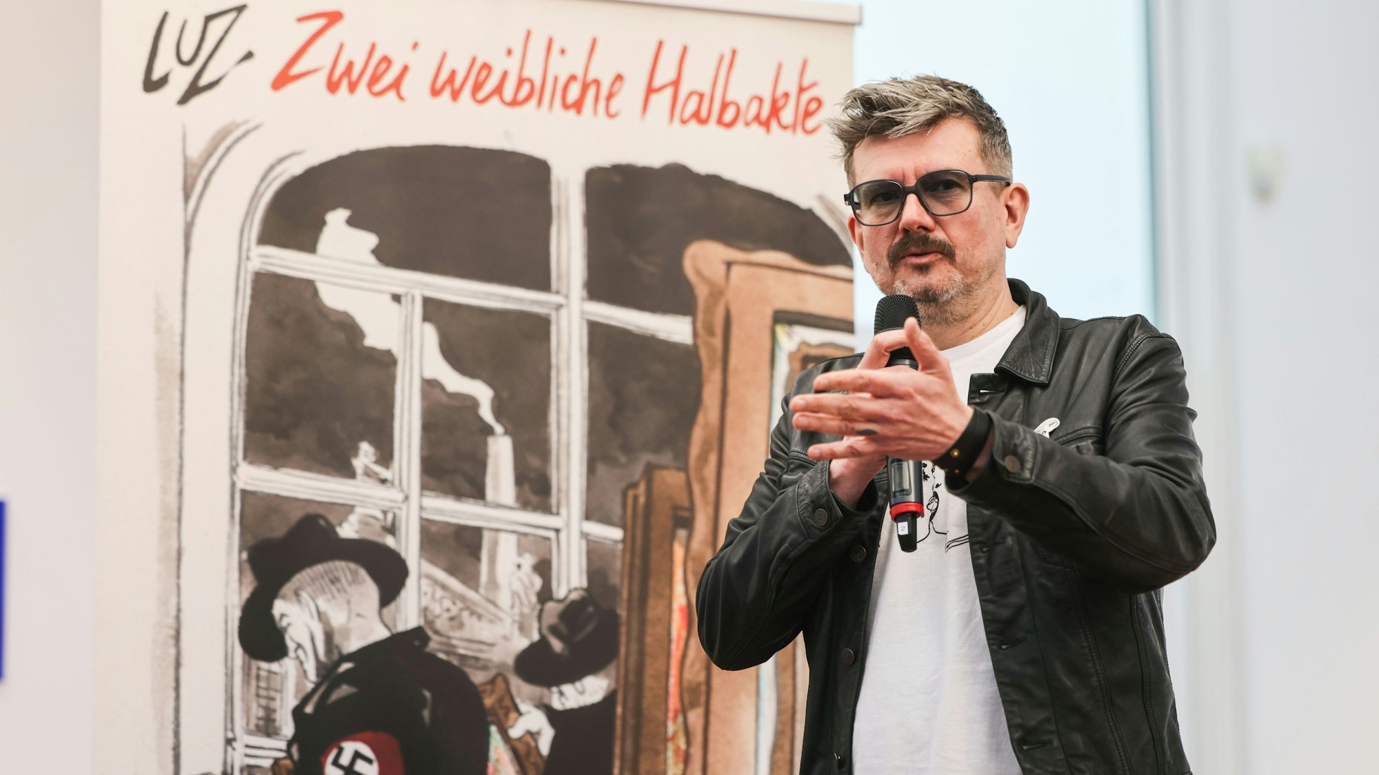 28.04.2025, Nordrhein-Westfalen, Köln: Der französische Karikaturist Luz steht bei der Vorstellung seines Comics «Zwei weibliche Halbakte» vor dem gleichnamigen Bild im Museum Ludwig. Luz war viele Jahre lang einer der wichtigsten Karikaturisten von «Charlie Hebdo». In seinem neuen Comic erzählt er die Geschichte des Bildes «Zwei weibliche Halbakte» (1919) von Otto Mueller, das von den Nazis als «entartet» eingestuft wurde.