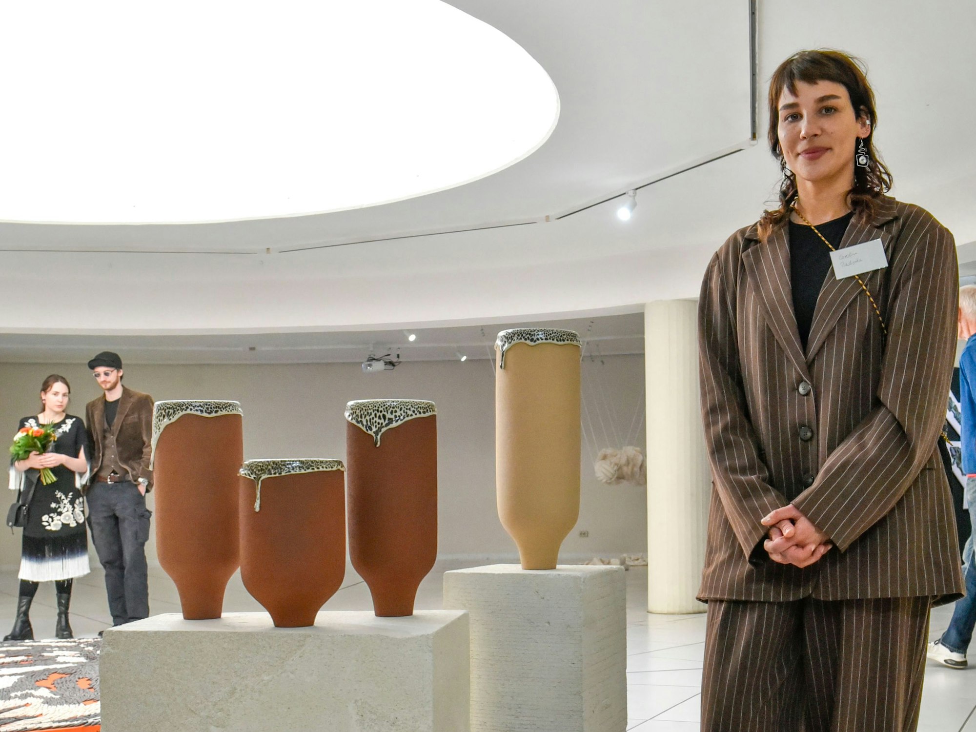 Auf dem Bild ist die Preisträgerin mit einigen ihrer Werke auf Sockeln zu sehen.