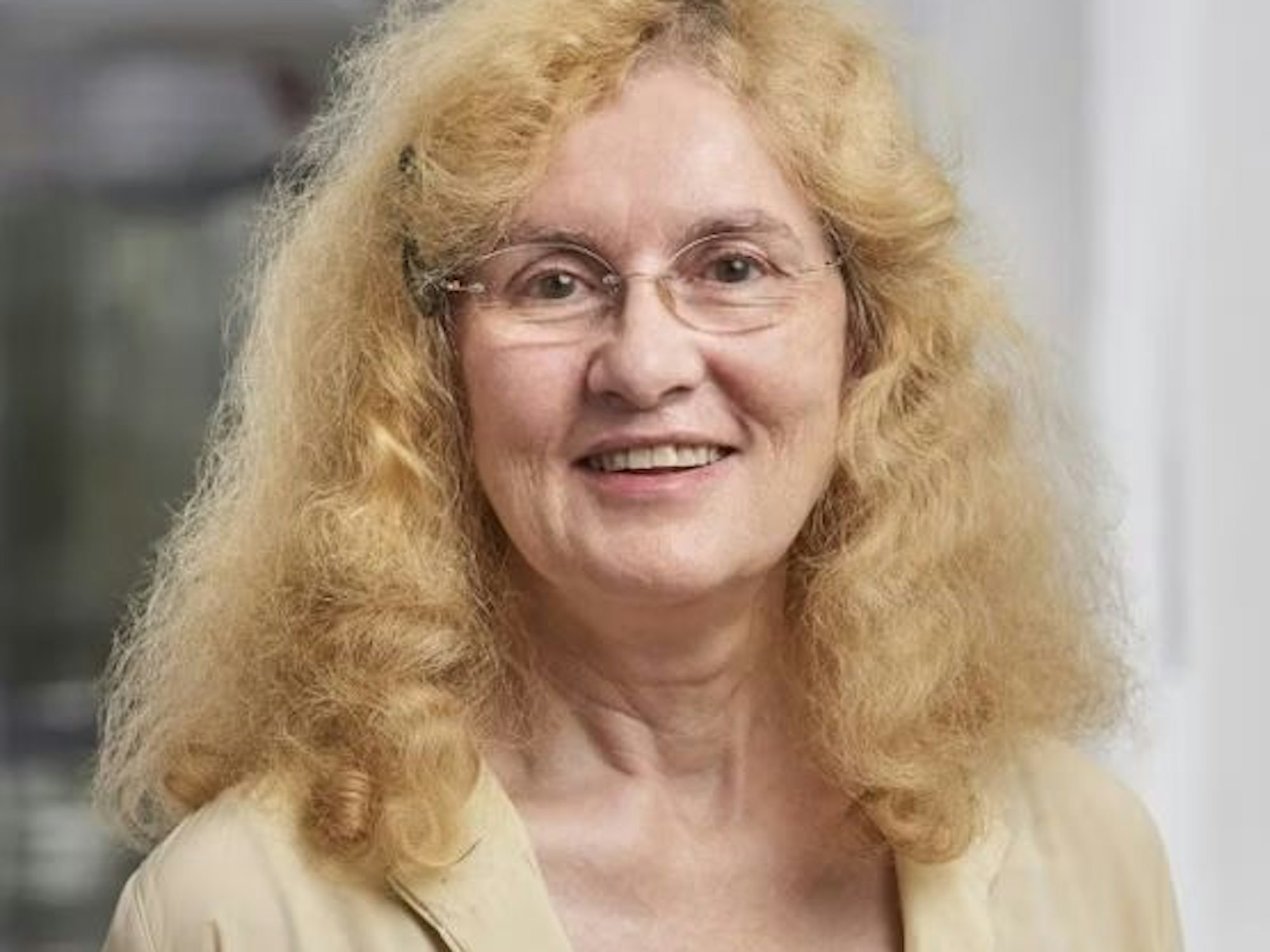 Monika Scheidt hat lange blonde Haare und trägt eine beige Bluse.