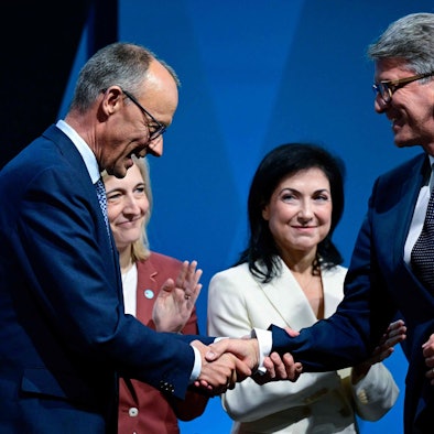 CDU leader Friedrich Merz (L) shakes hands with Wolfram Weimer, designated German Minister for Culture and Media, during the federal committee meeting of Germany's conservative Christian Democratic Union (CDU) party, on April 28, 2025 in Berlin. The committee adopted the coalition agreement negotiated with the social democratic SPD party. (Photo by John MACDOUGALL / AFP)