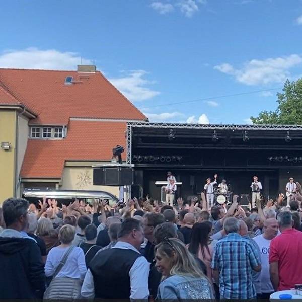 Blick auf die Bühne mit zahlreichen Zuschauern davor.