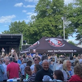 Blick auf die Bühne mit zahlreichen Zuschauern davor.