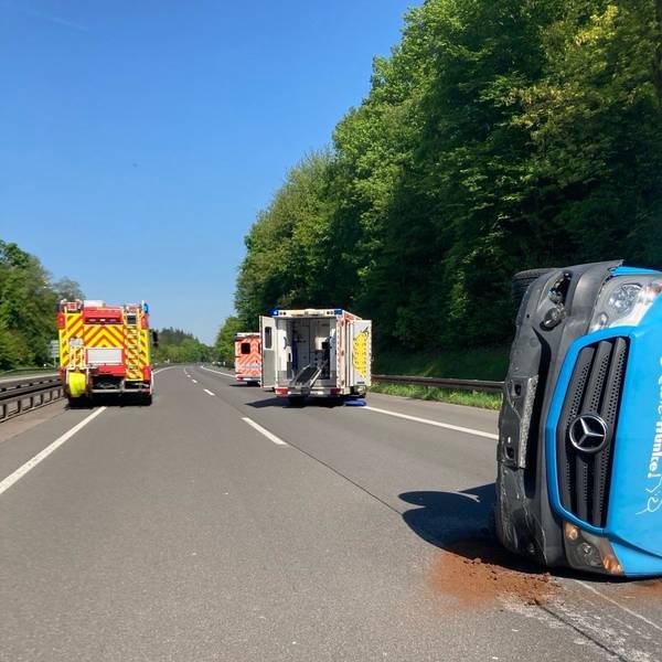 Auf der Autobahn liegt ein Transporter auf der Seite, dahinter stehe zwei Krankenwagen und ein Feuerwehrfahrzeug.