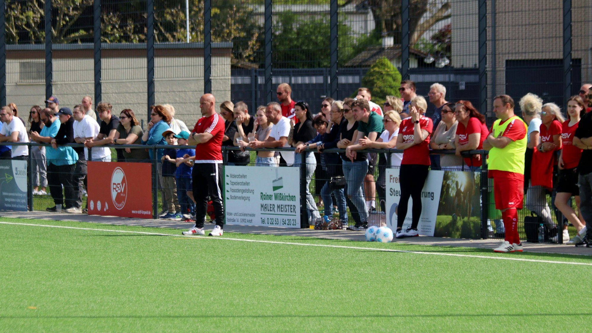Zahlreiche Zuschauer verfolgen ein Heimspiel des RSV Arloff-Kirspenich. Direkt am Spielfeldrand stehen Ex-Trainer Sven Gräbe (l.) und Sportchef Christian Zimmermann.