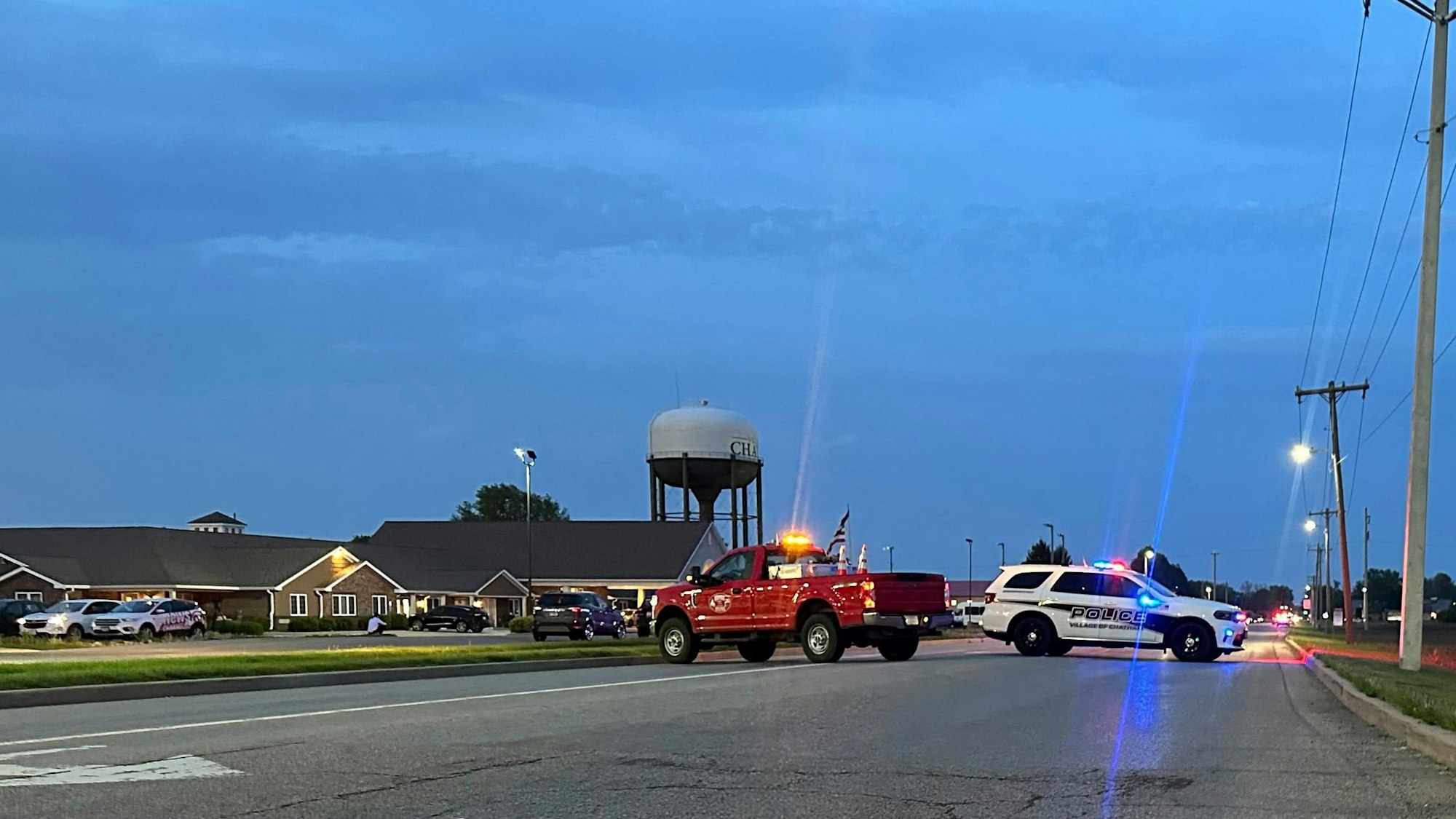 28.04.2025, USA, Chatham: Rettungsfahrzeuge blockieren eine Straße, die zu einem Schulgebäude führt, in das ein Auto gefahren wurde, wobei mehrere Menschen getötet und andere verletzt wurden. Foto: John O'Connor/AP/dpa +++ dpa-Bildfunk +++