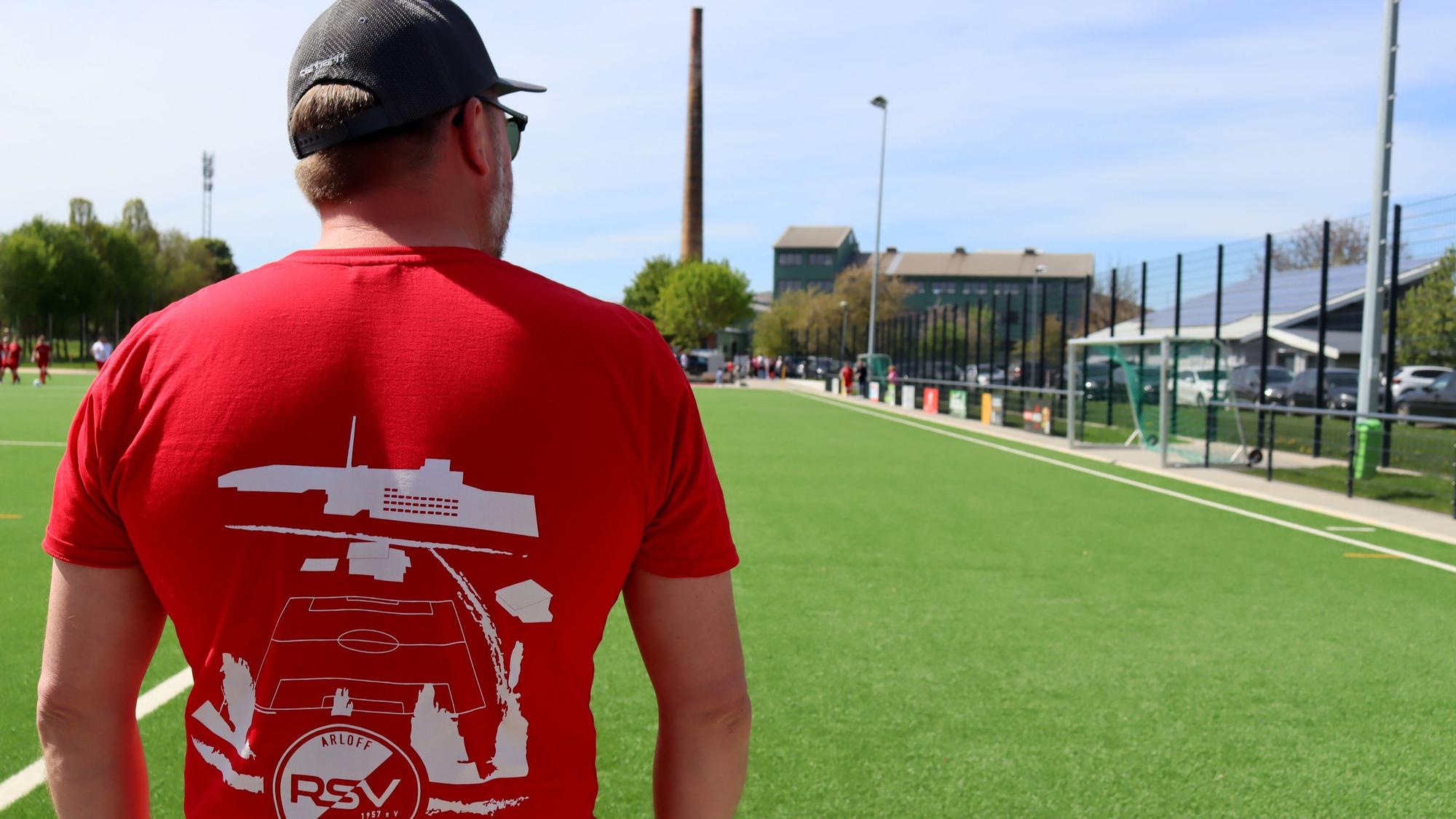 Die Rückseite eines T-Shirts zeigt die Silhouette der Arloffer Thonwerke, die im Hintergrund in natura zu sehen sind.