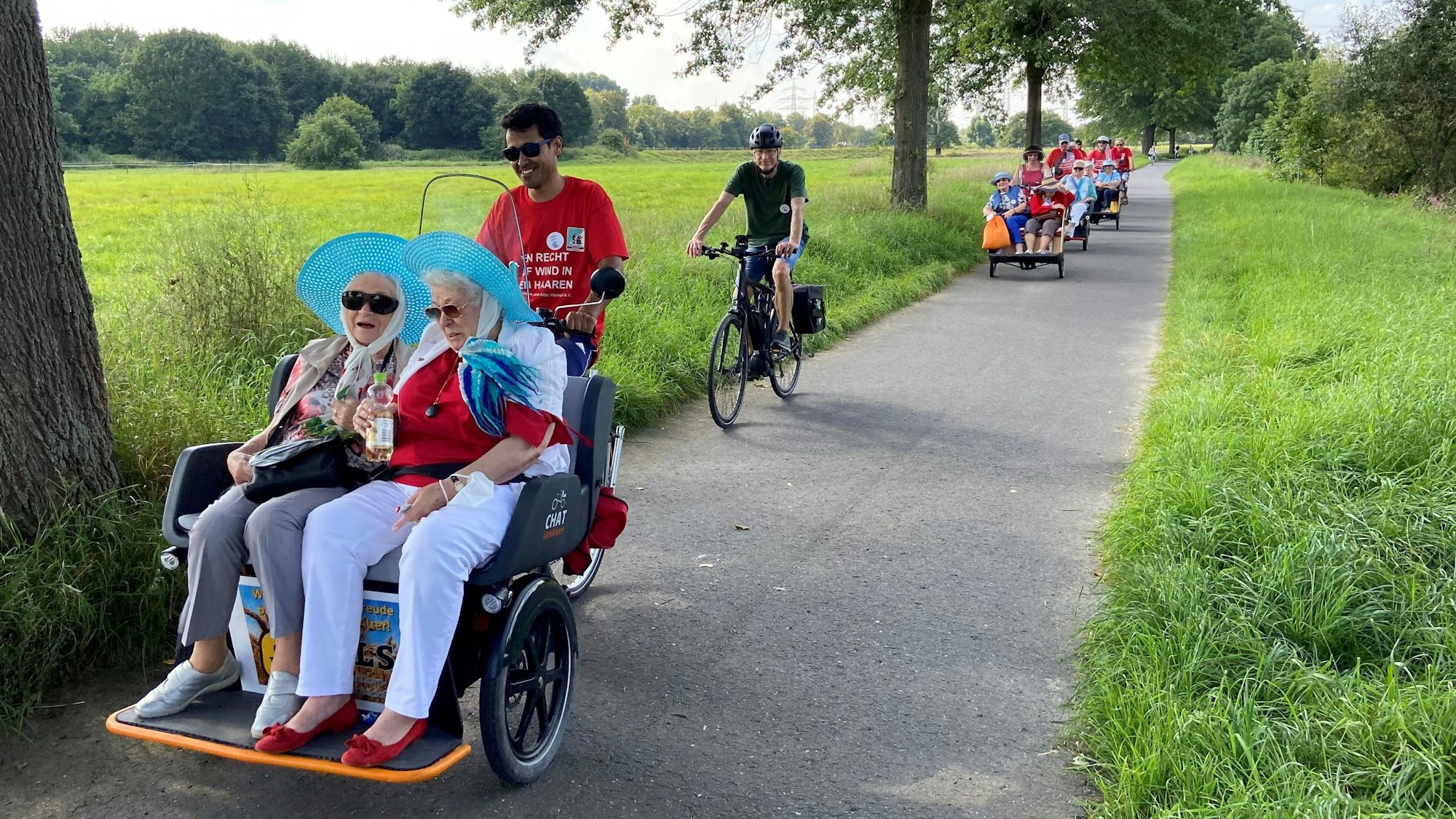 Ehrenamtliche fahren Seniorinnen und Senioren für den Verein „Radeln ohne Alter“ durch die Natur.