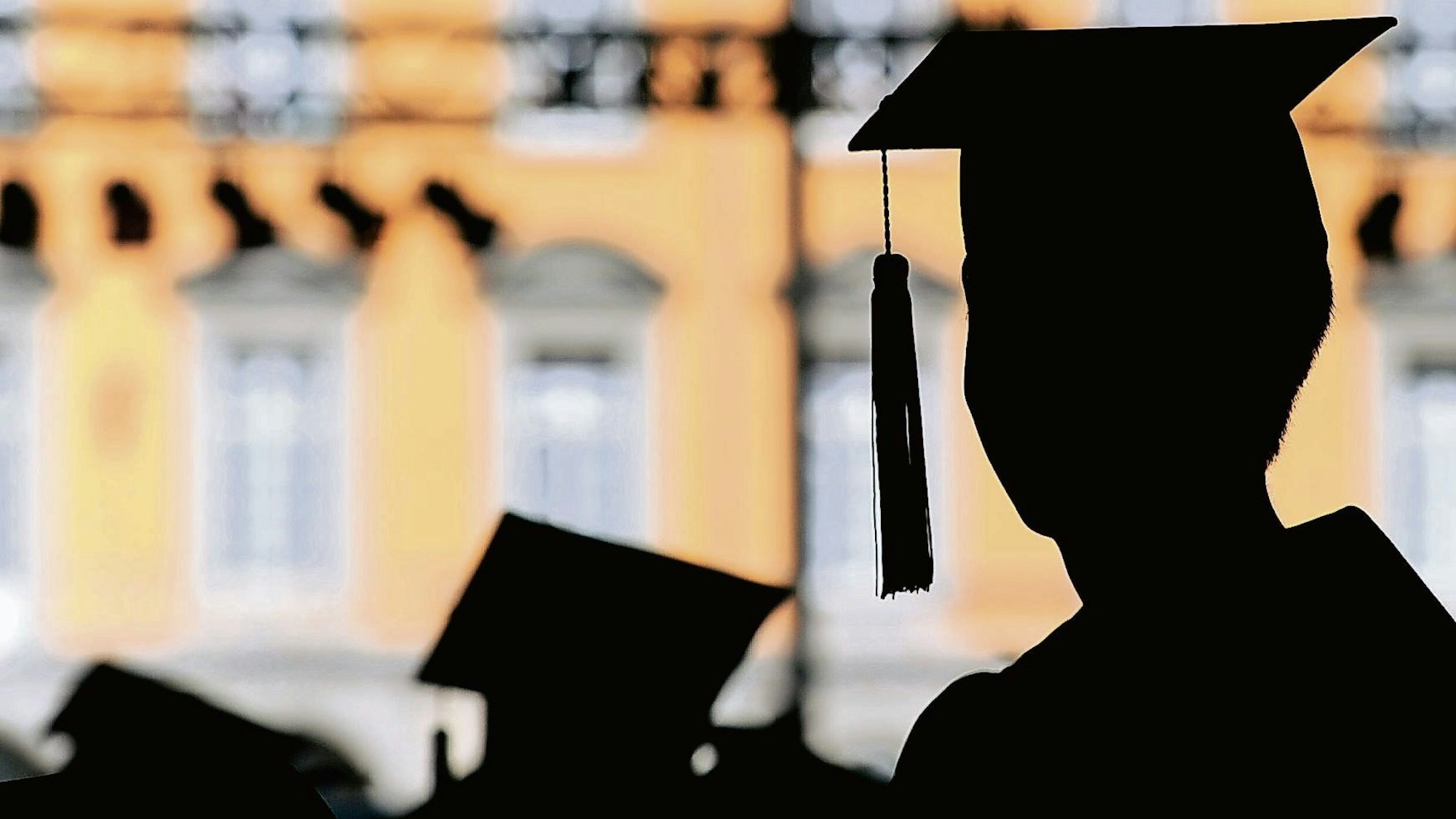 Absolventen der Rheinischen Friedrich-Wilhelms-Universität feiern am auf dem Campus in Talare gekleidet ihren Abschluss.
