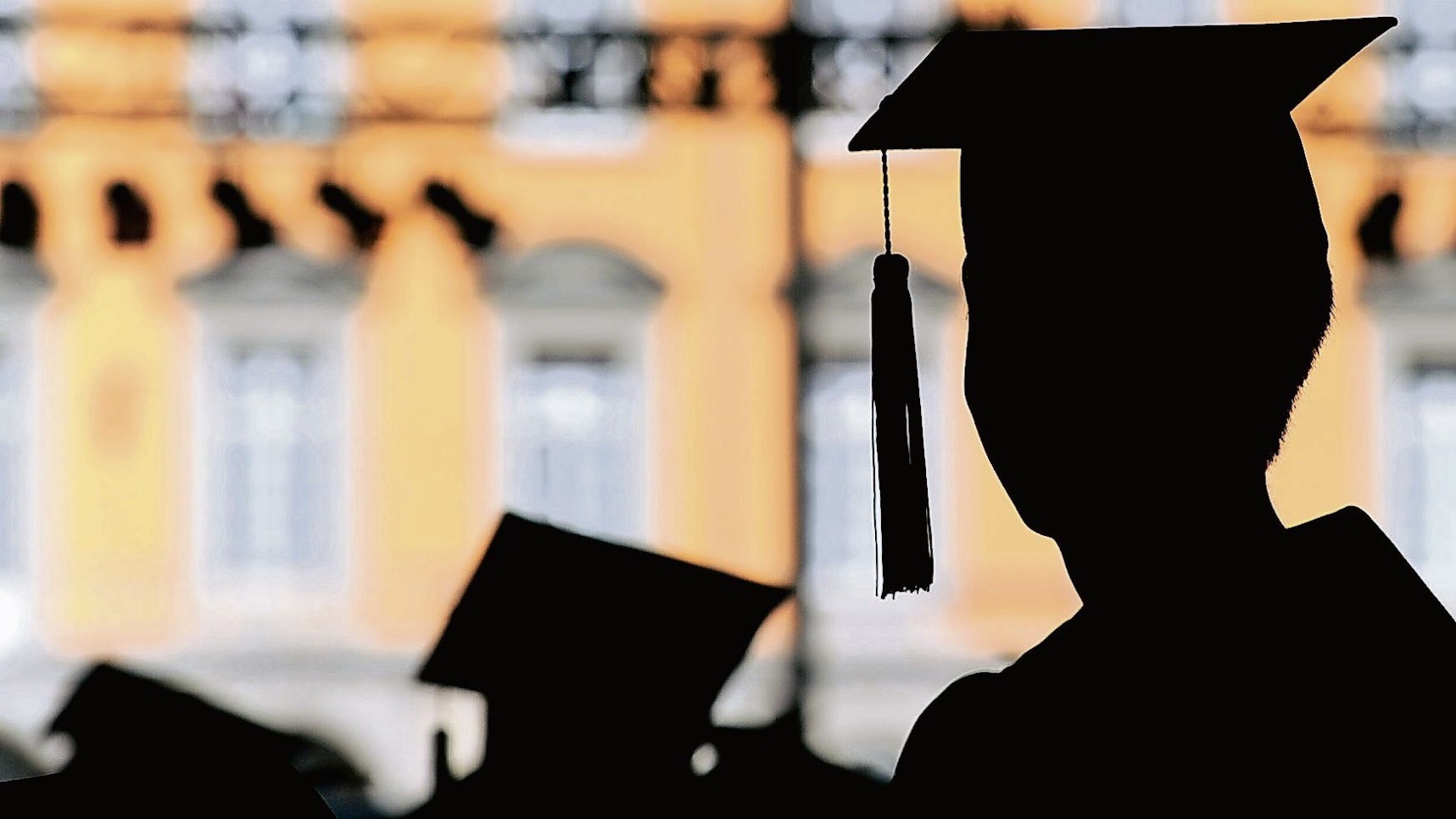 Absolventen der Rheinischen Friedrich-Wilhelms-Universität feiern am auf dem Campus in Talare gekleidet ihren Abschluss.