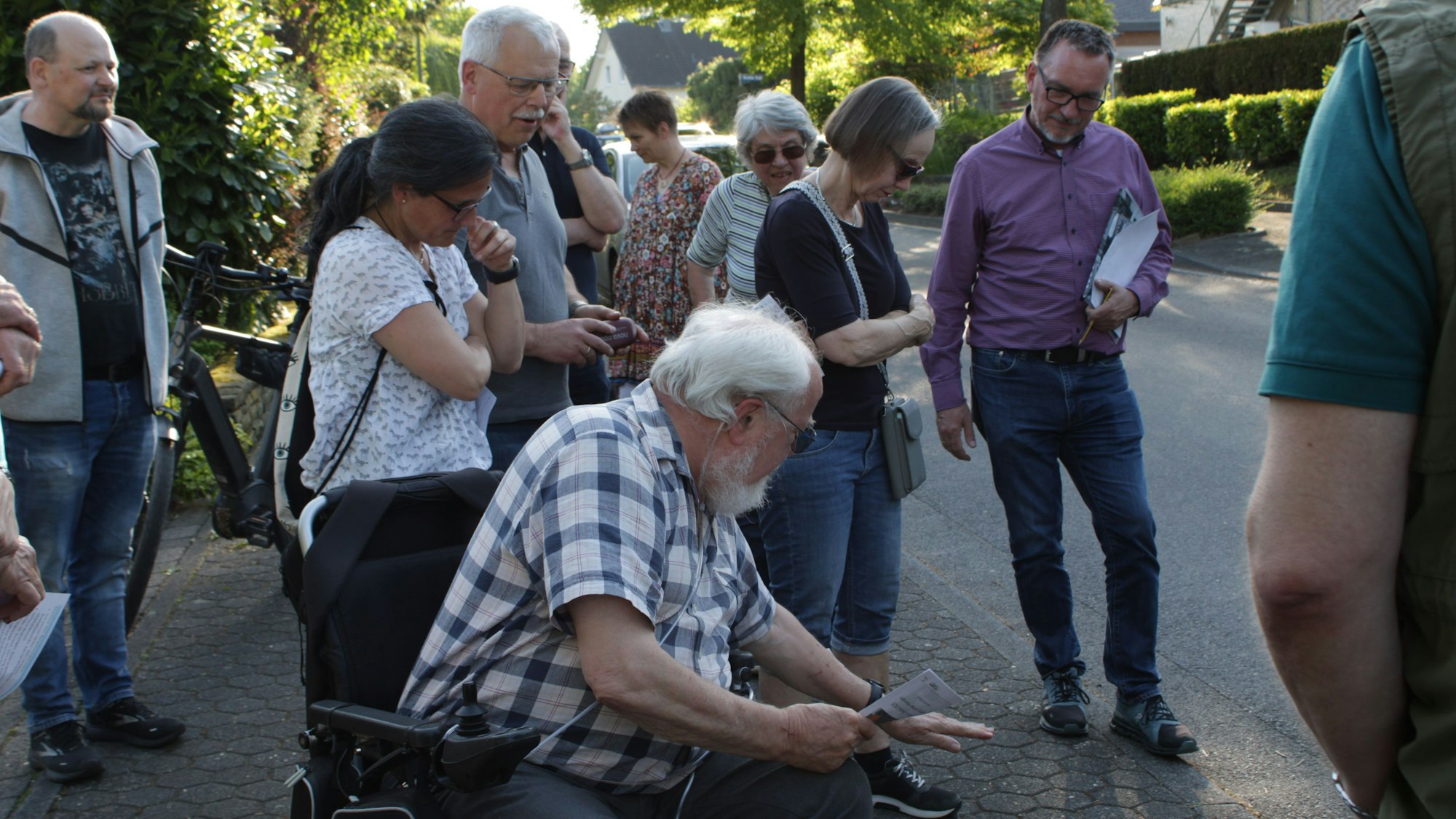 Der im Rollstuhl sitzende Anwohner Dieter Schneider zeigt, was abgesenkte Bordsteine in seinem Alltag bedeuten.