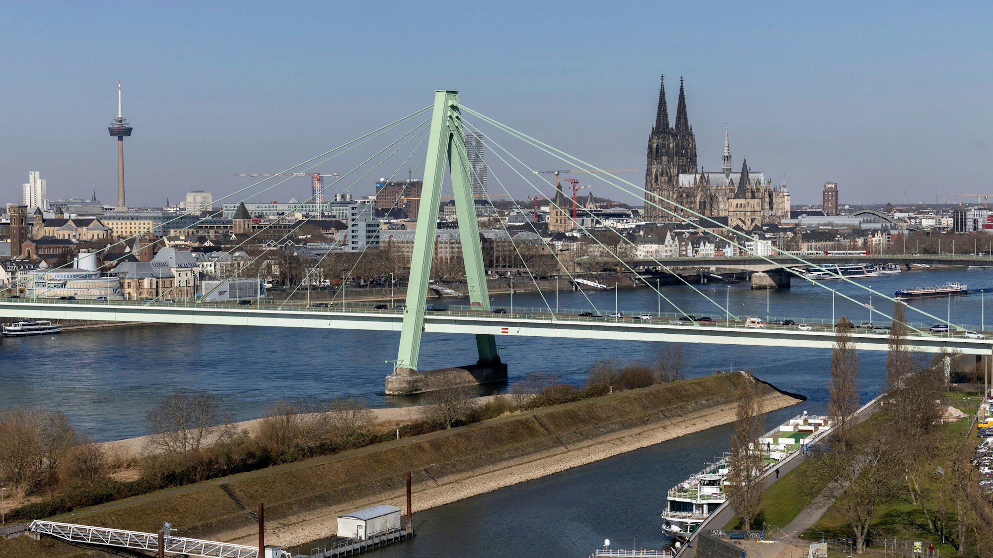 19.03.2025, Köln: Stadtansichten gesehen von der Auermühle am Deutzer Hafen.
Im Bild Blick auf die Severinsbrücke mit dem Eingang zum Deutzer Hafen und Drehbrücke im Vordergrund und dem Dom und Rhein im Hintergrund.
Foto: Michael Bause