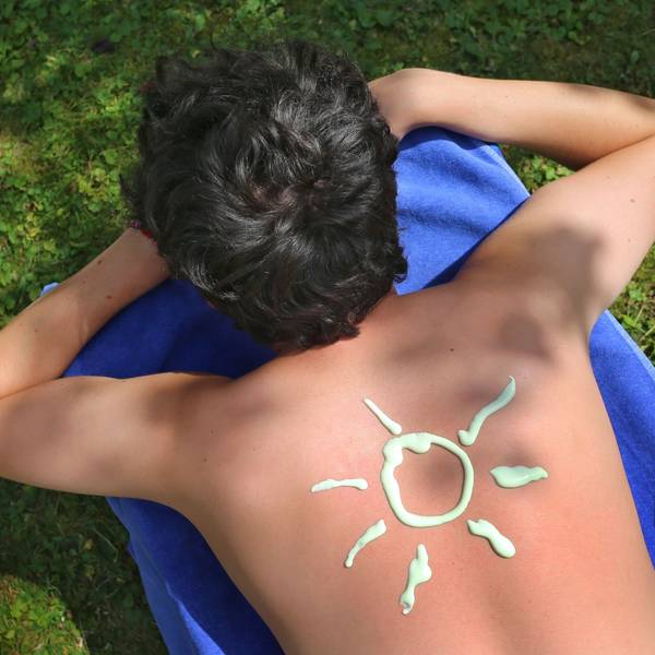 Eine Sonnencreme-Sonne ist auf einem Rücken zu sehen. (Archivbild)