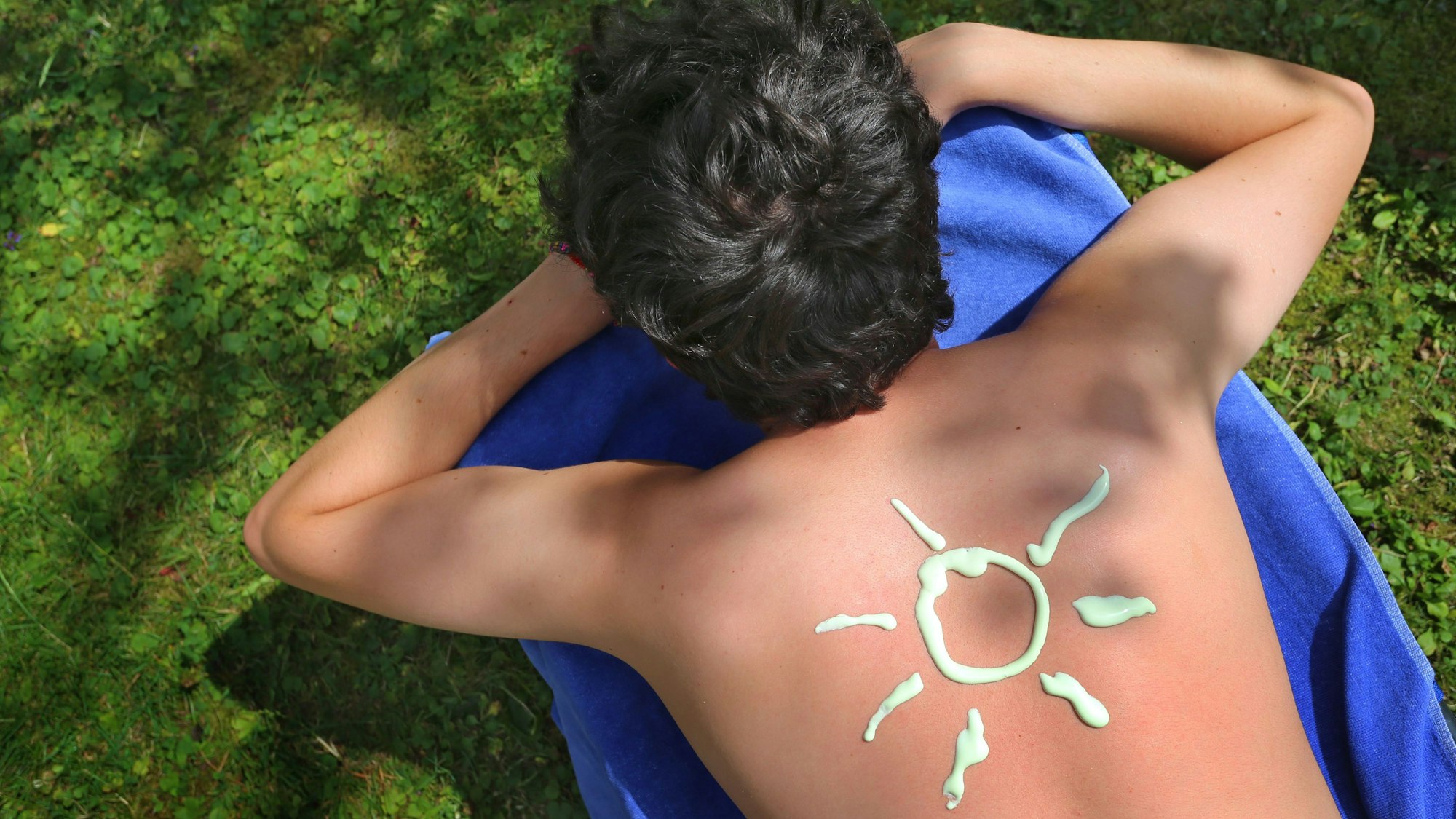Eine Sonnencreme-Sonne ist auf einem Rücken zu sehen. (Archivbild)