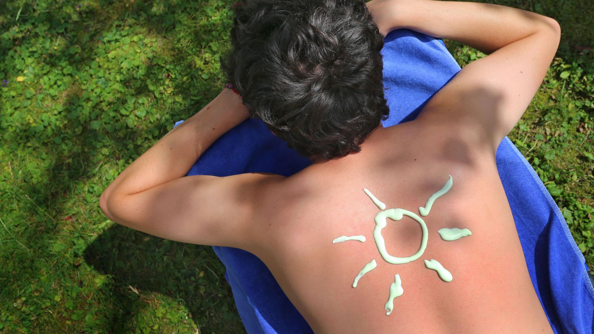 Eine Sonnencreme-Sonne ist auf einem Rücken zu sehen
