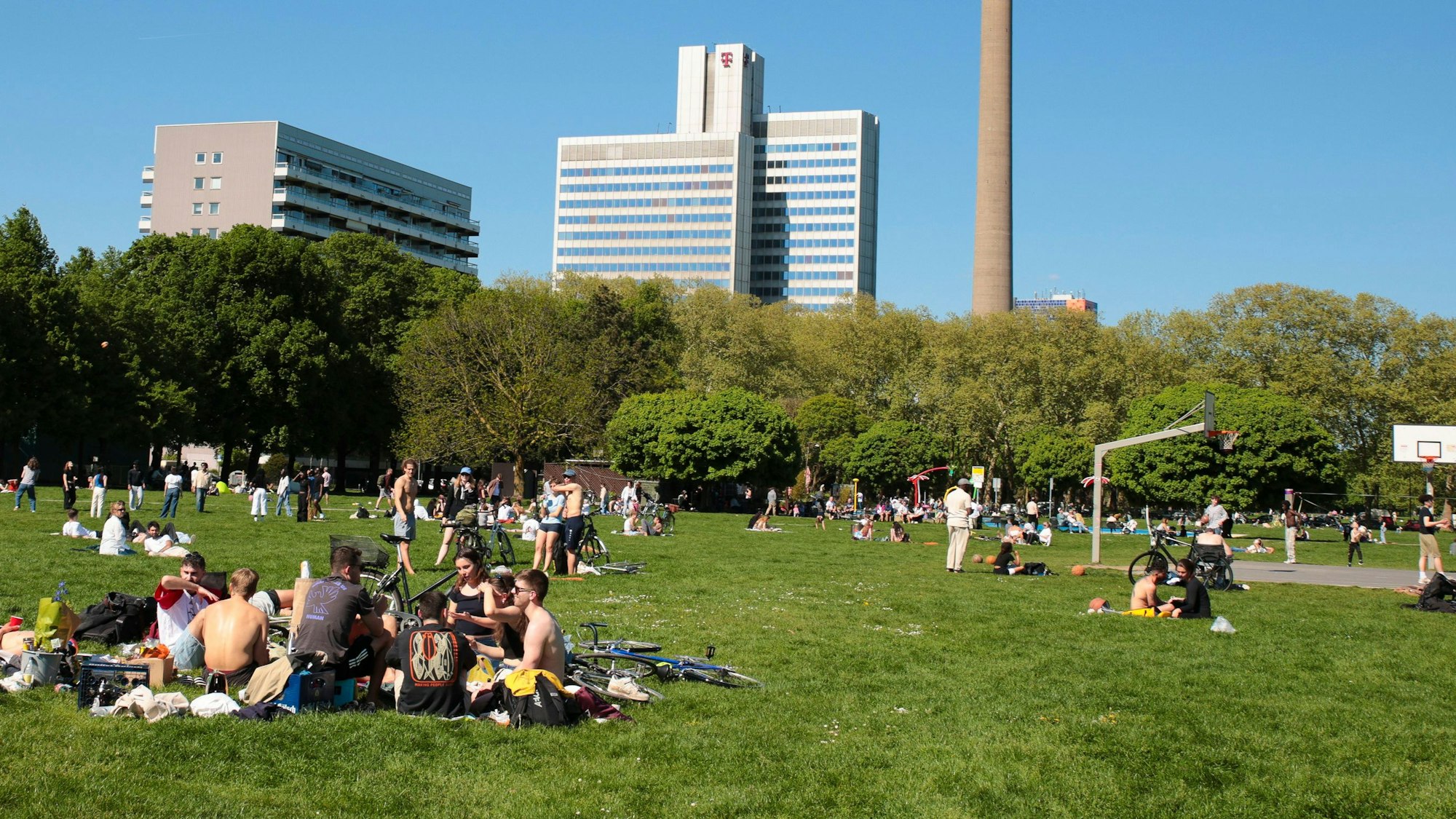 Der Grüngürtel mit jungen Besuchenden, die sich in Gruppen zusammengesetzt haben. Mit dem Apéro Markt soll so dort eine Alternative zum Brüsseler Platz geboten werden.