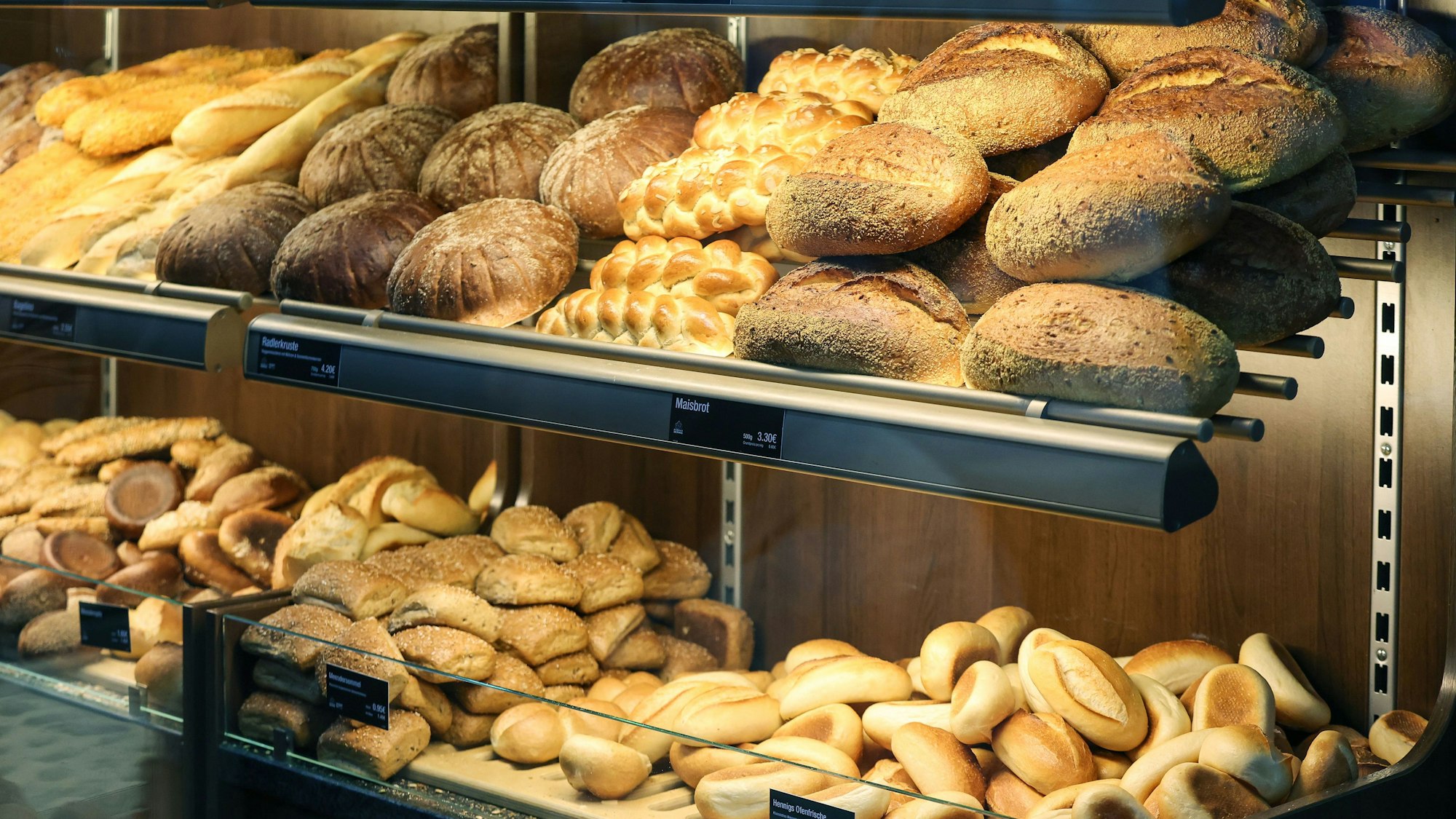 Das Bild zeigt mit Brot und Brötchen gefüllte Regale einer Bäckerei.