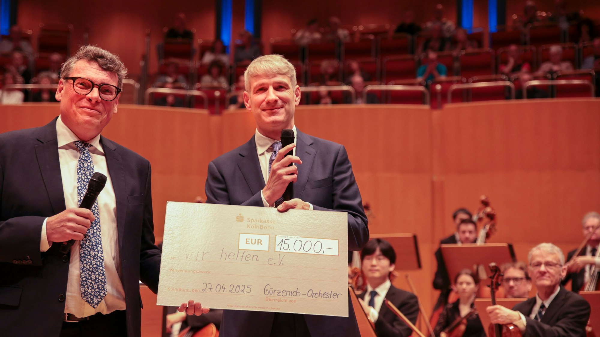 Der Direktor des Gürzenich-Orchesters Stefan Englert (rechts)  überreicht in der ausverkauften Kölner Philharmonie einen symbolischen Scheck in Höhe von 15.000 Euro an den Chefredakteur des Kölner Stadt-Anzeigers Gerald Selch.