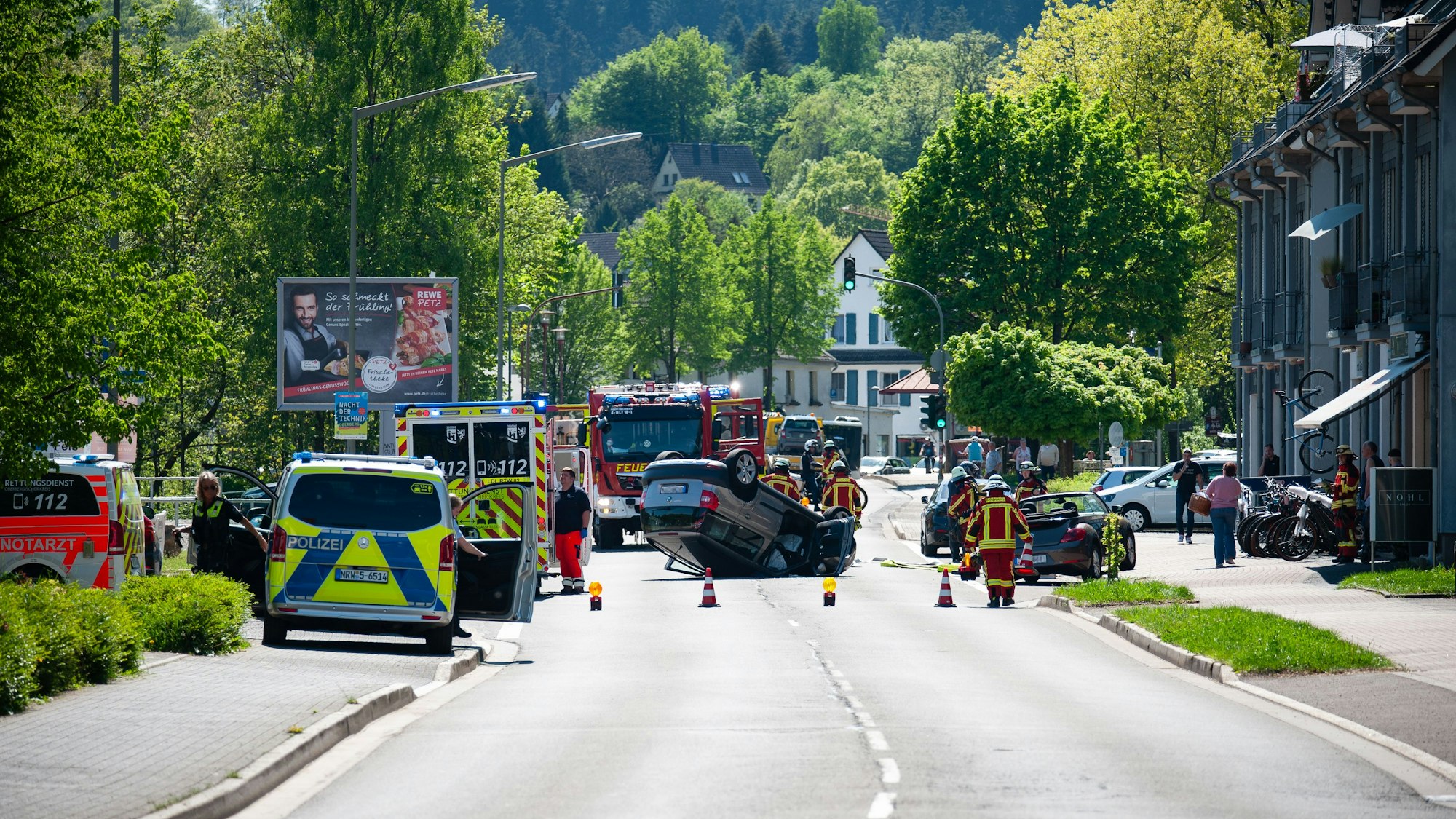 Ein Unfallauto liegt auf einer Straße auf dem Dach.