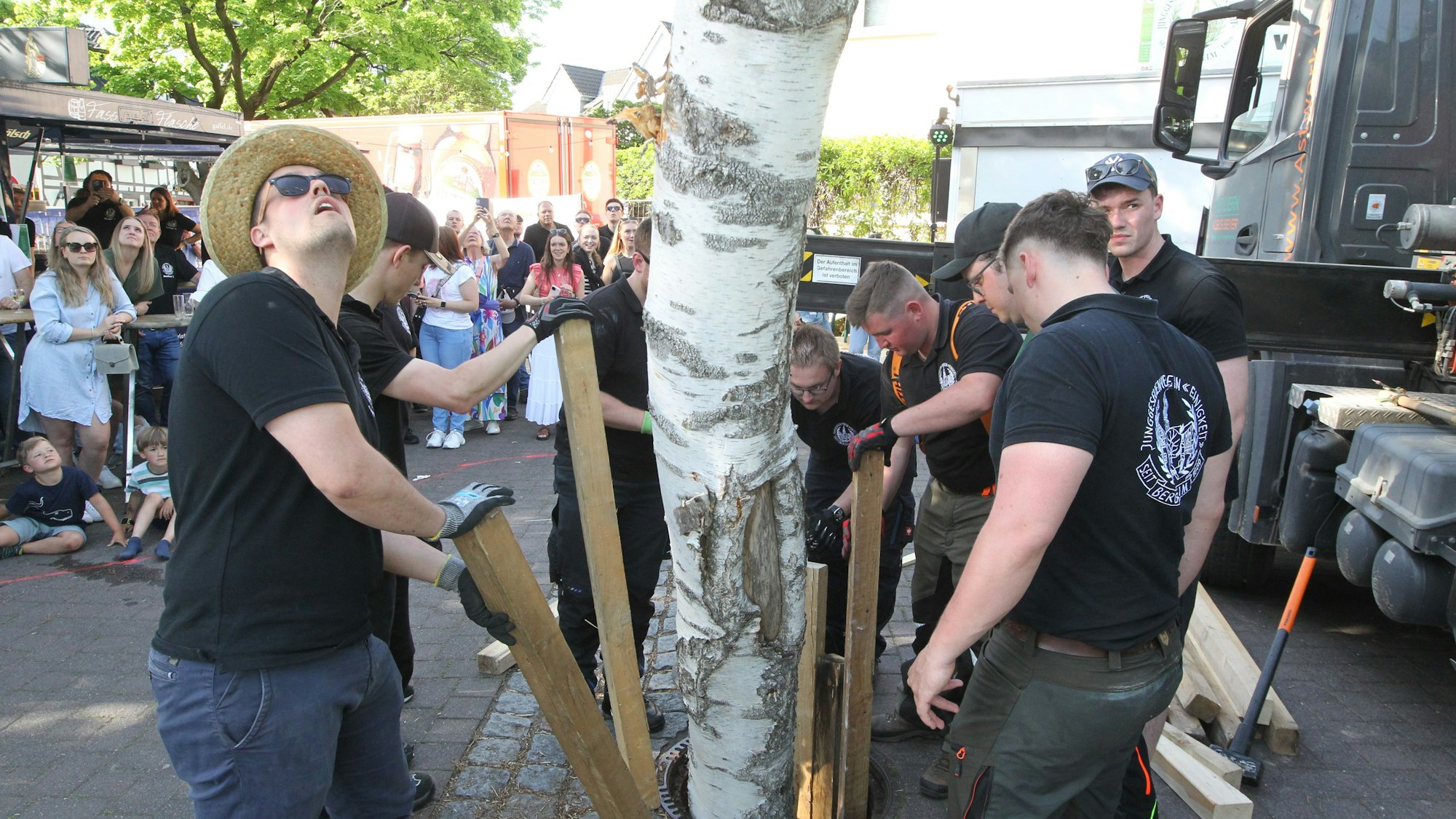 Mit Hölzern wird der Maibaum fixiert.