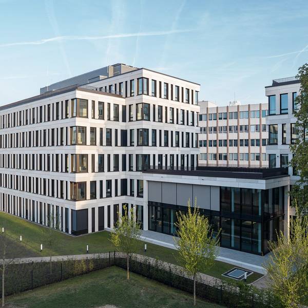 Ein neues mehrgeschossiges Bürogebäude steht an einer Straße.