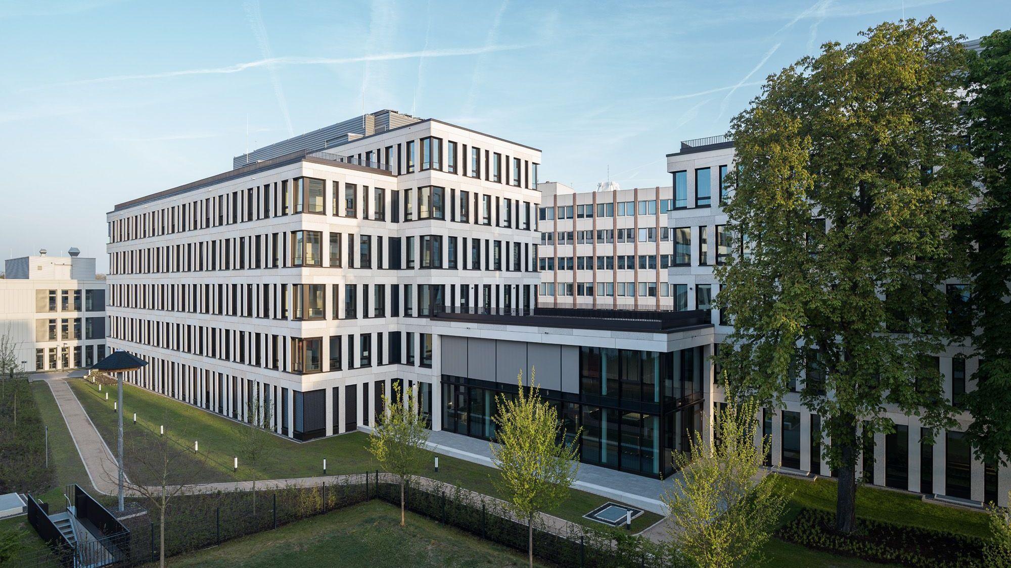 Ein neues mehrgeschossiges Bürogebäude steht an einer Straße.