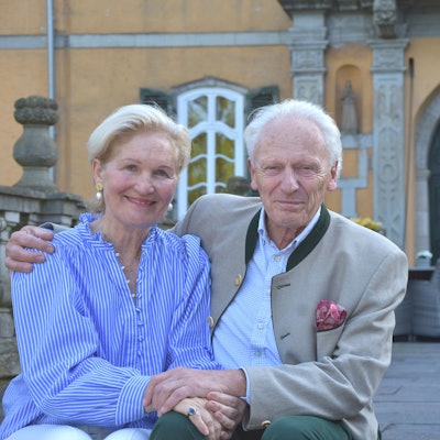 Eine Frau und ein Mann lächeln in die Kamera, er hält sie im Arm.